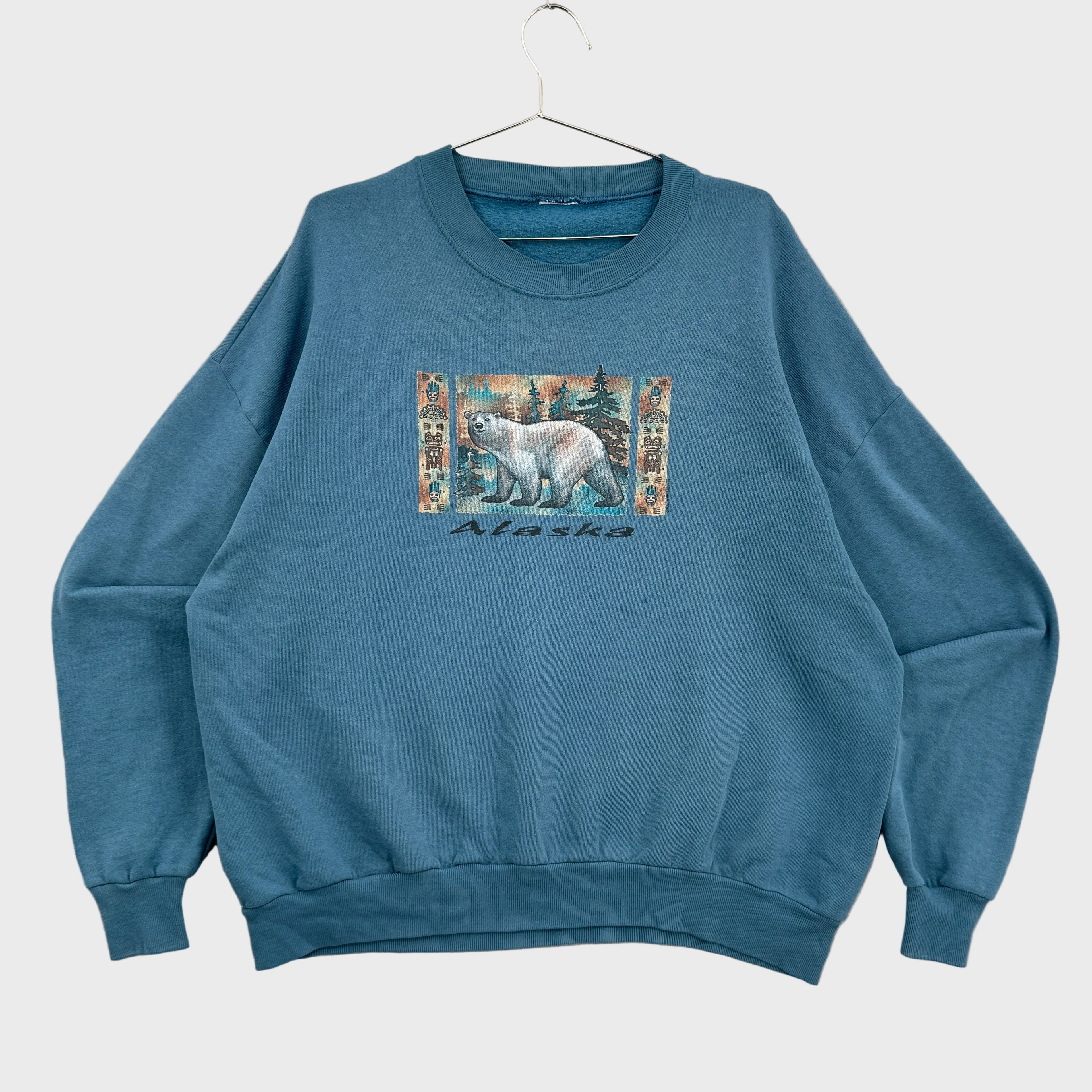Blue sweatshirt with a polar bear bear graphic and 'Alaska' text on a beige background