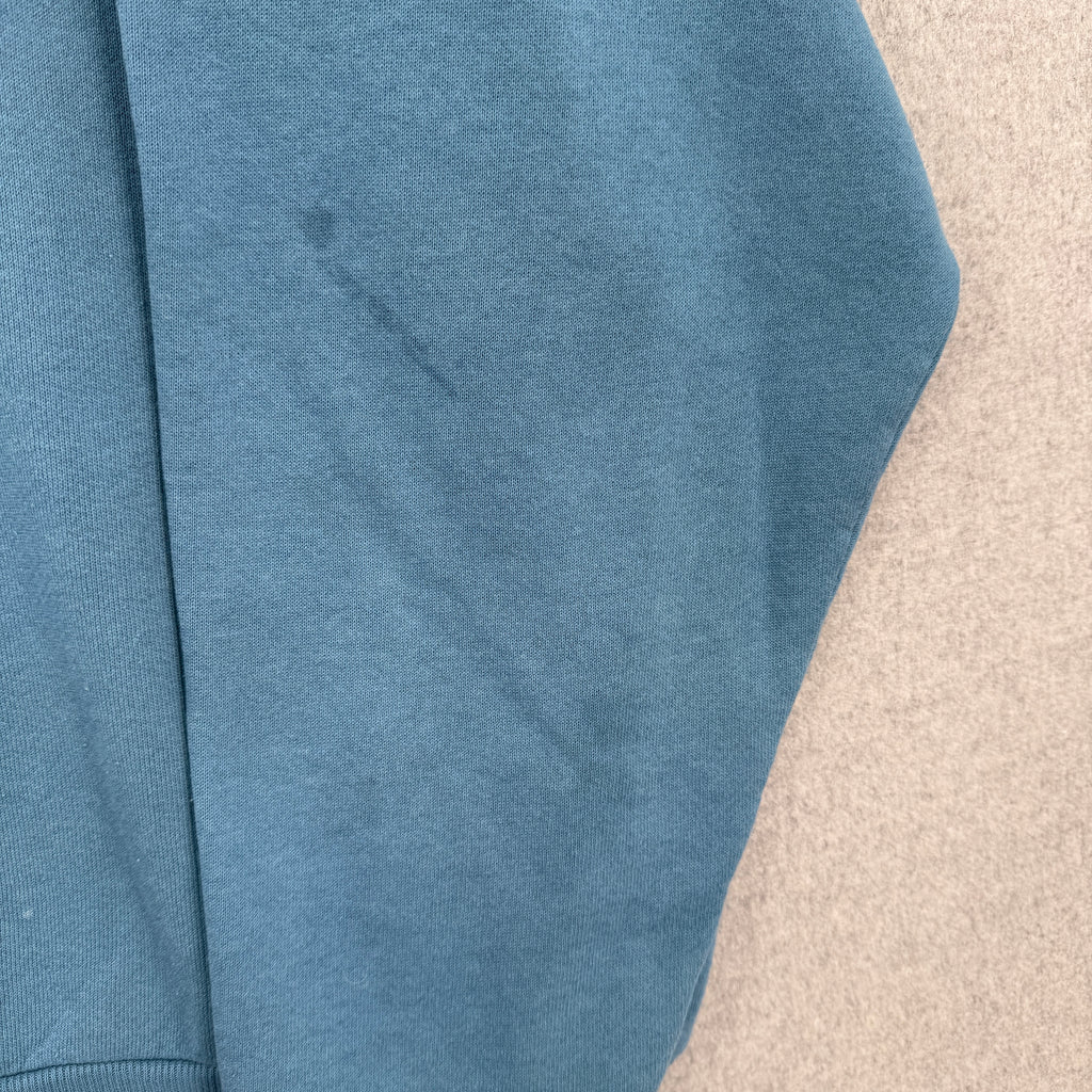 Blue sweater with stain spot on sleeve