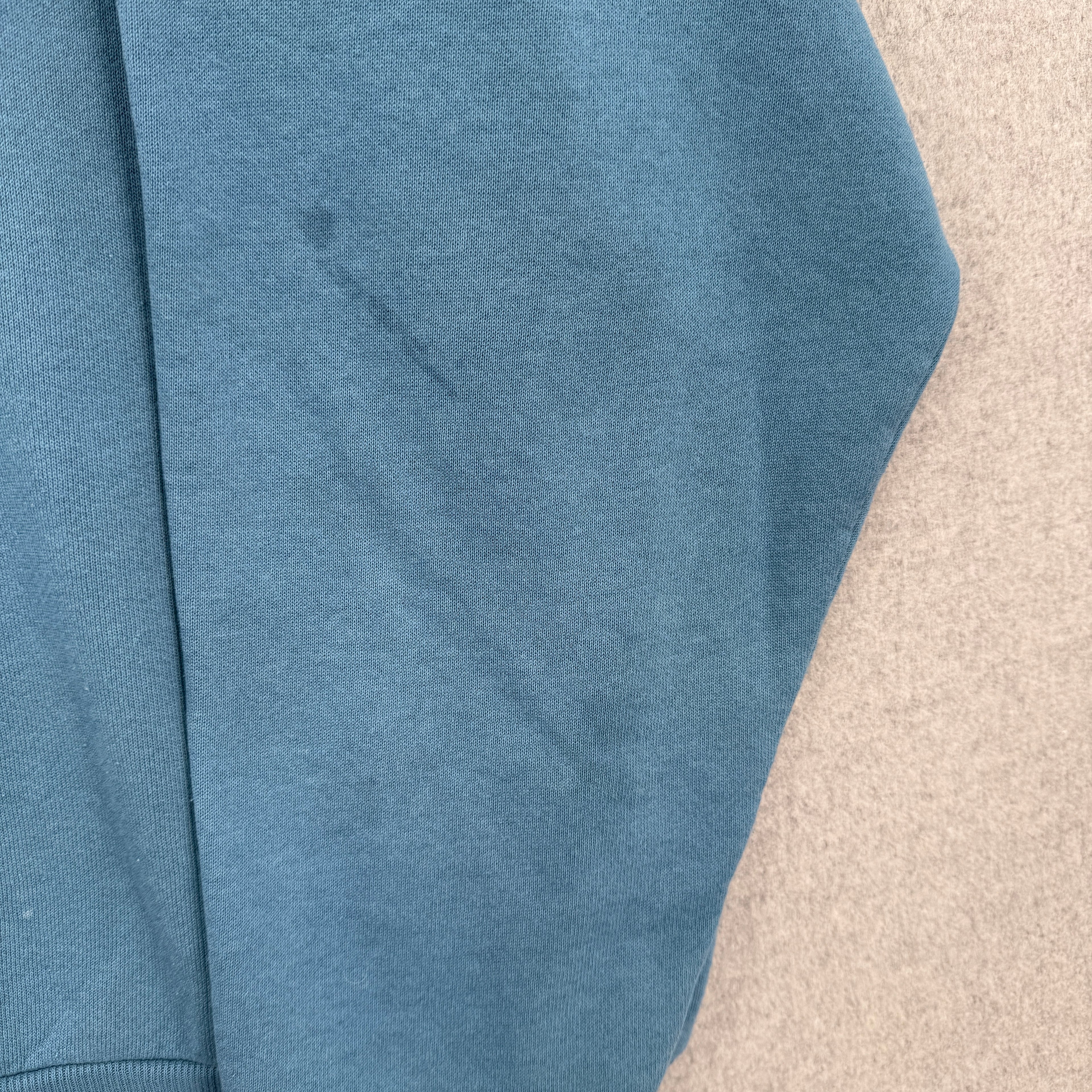 Blue sweater with stain spot on sleeve