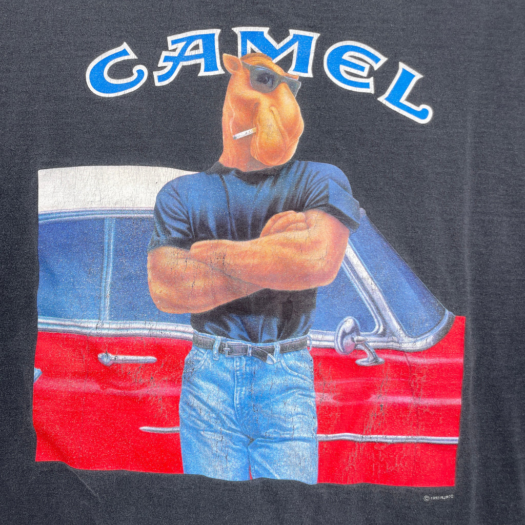 Camel brand logo with a camel character standing next to a red car on a dark background