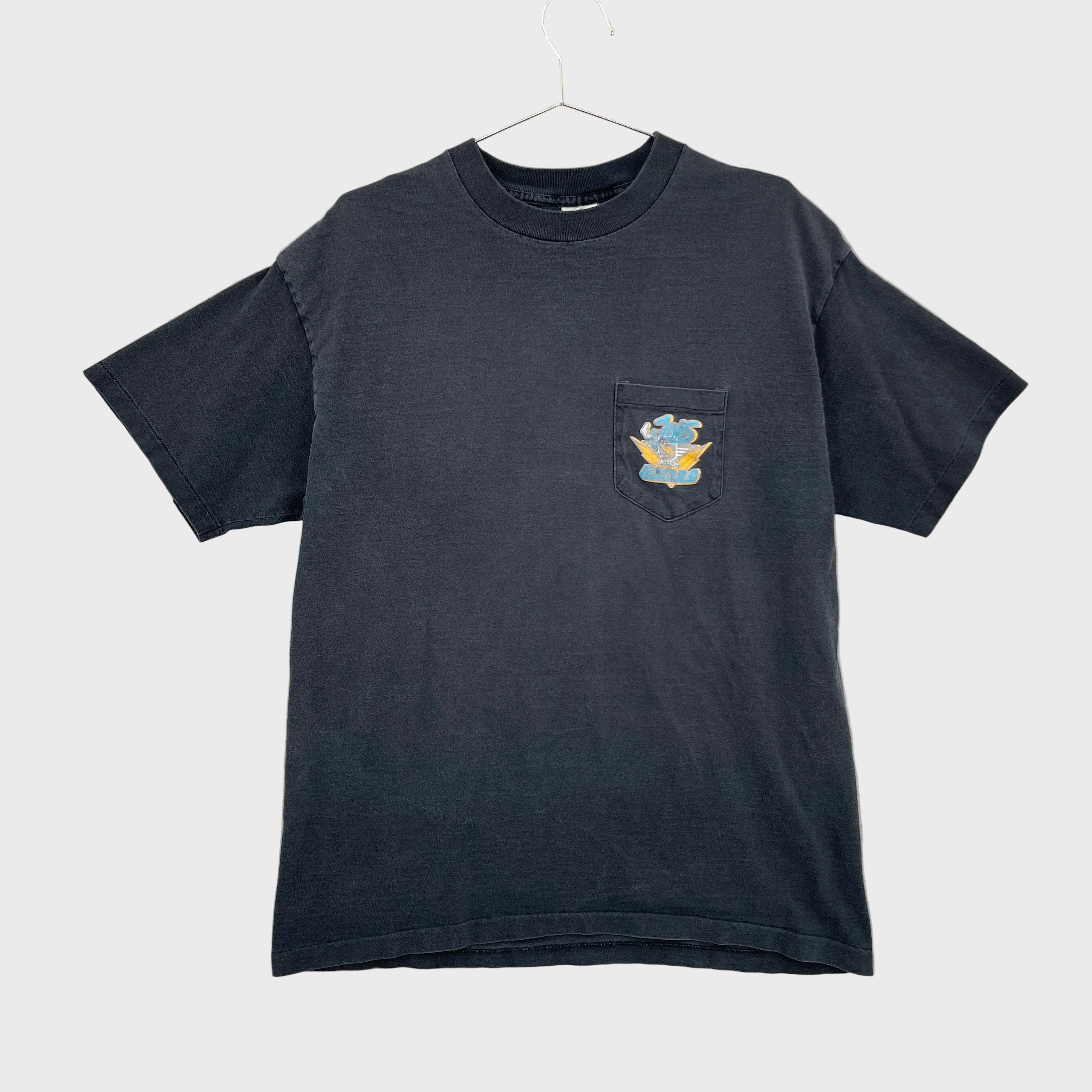Faded black t-shirt with a colorful logo on a front pocket displayed on a gray background