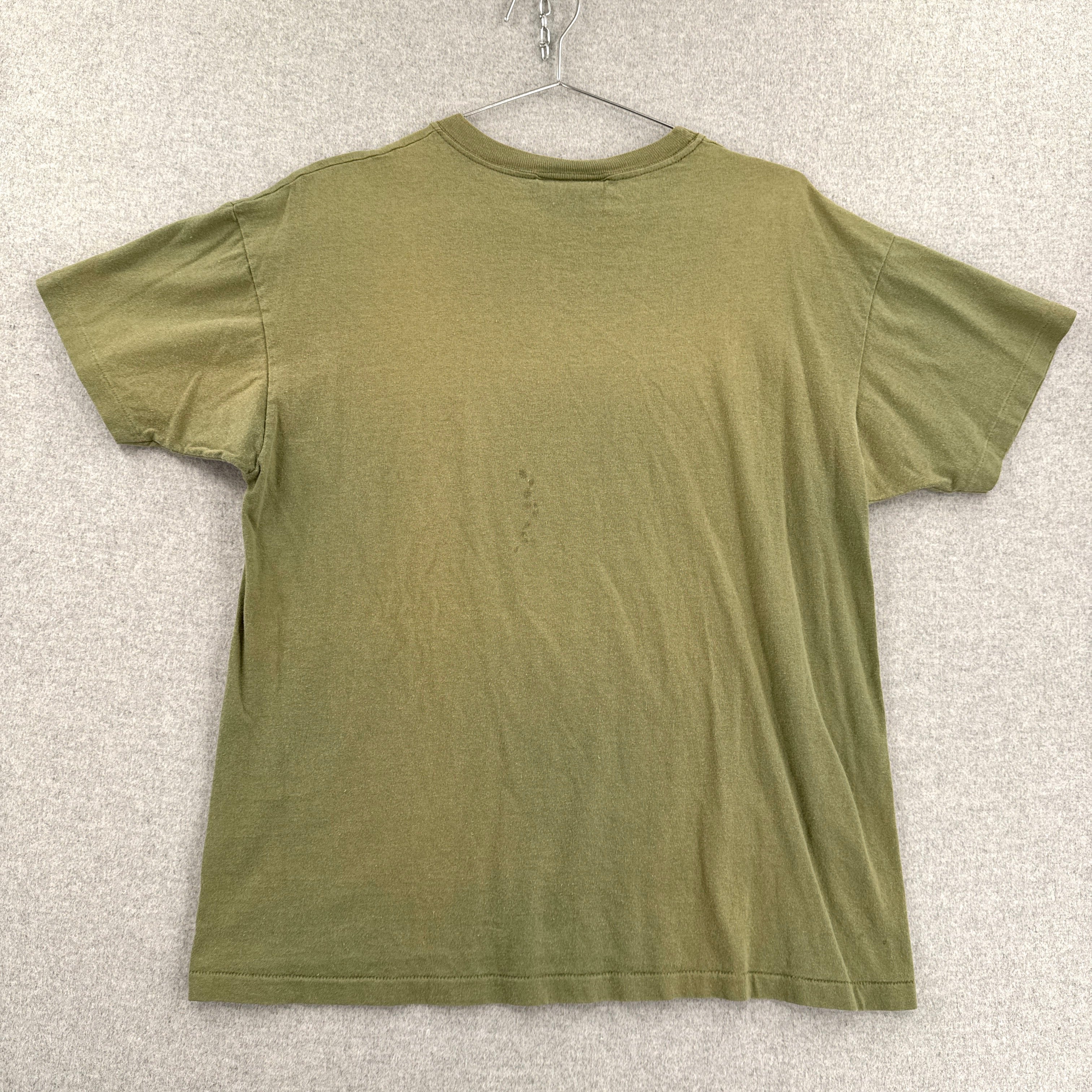 back of green t-shirt on a hanger against a textured white background
