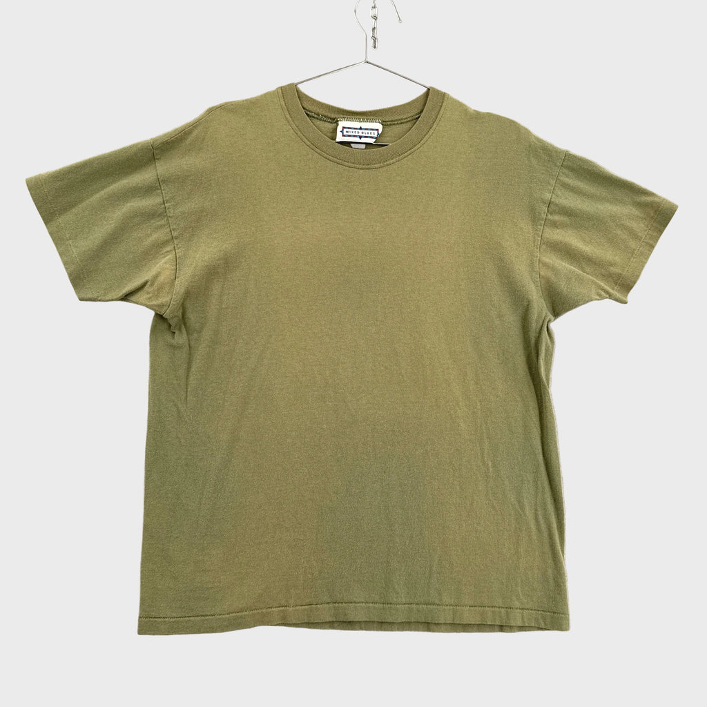 Green t-shirt on a hanger against a neutral background
