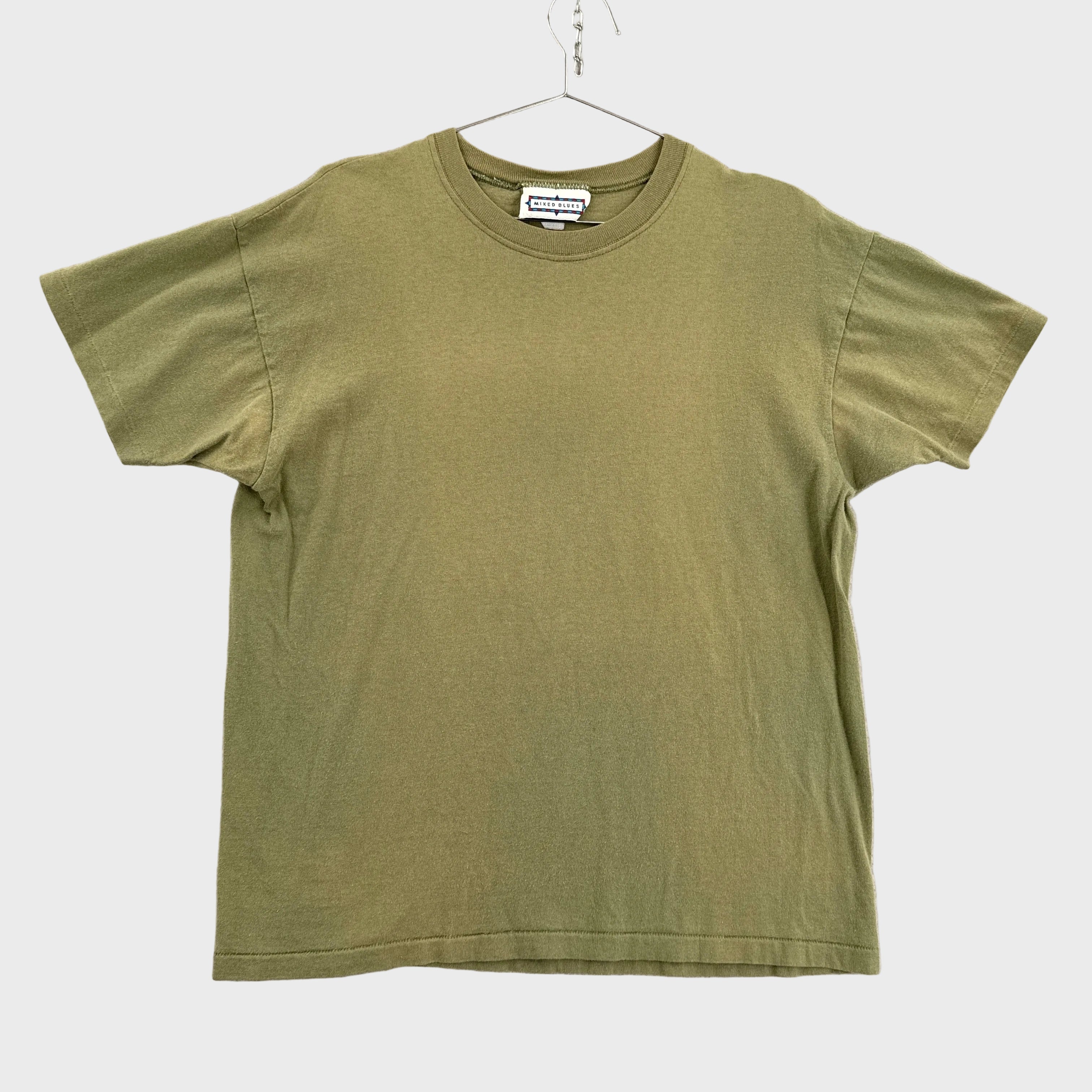 Green t-shirt on a hanger against a neutral background