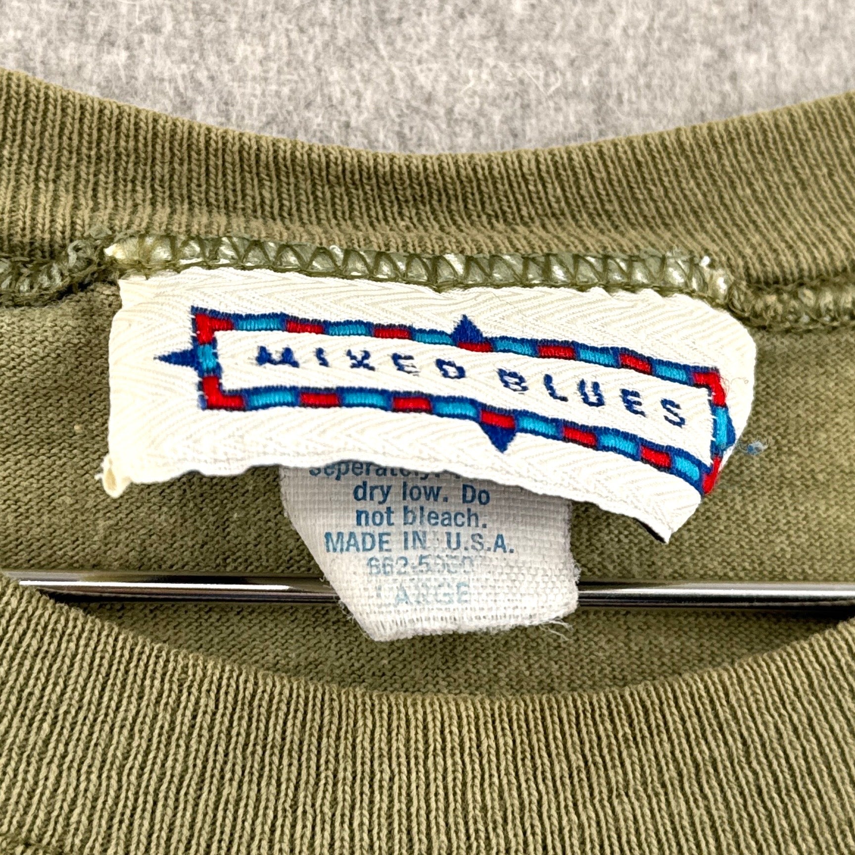 Label on a green garment with 'MIXED BLUES' branding. Made in USA size Large