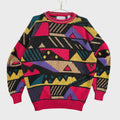 Colorful geometric patterned sweater on a beige surface. Red, pink, purple, yellow