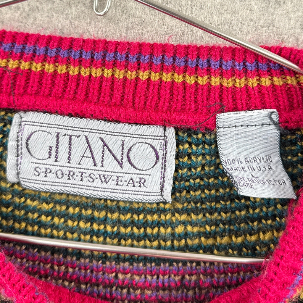 Close-up of a colorful knitted garment with 'Gitano Sportswear' labels on a neutral background. 100% acrylic made in USA size Large