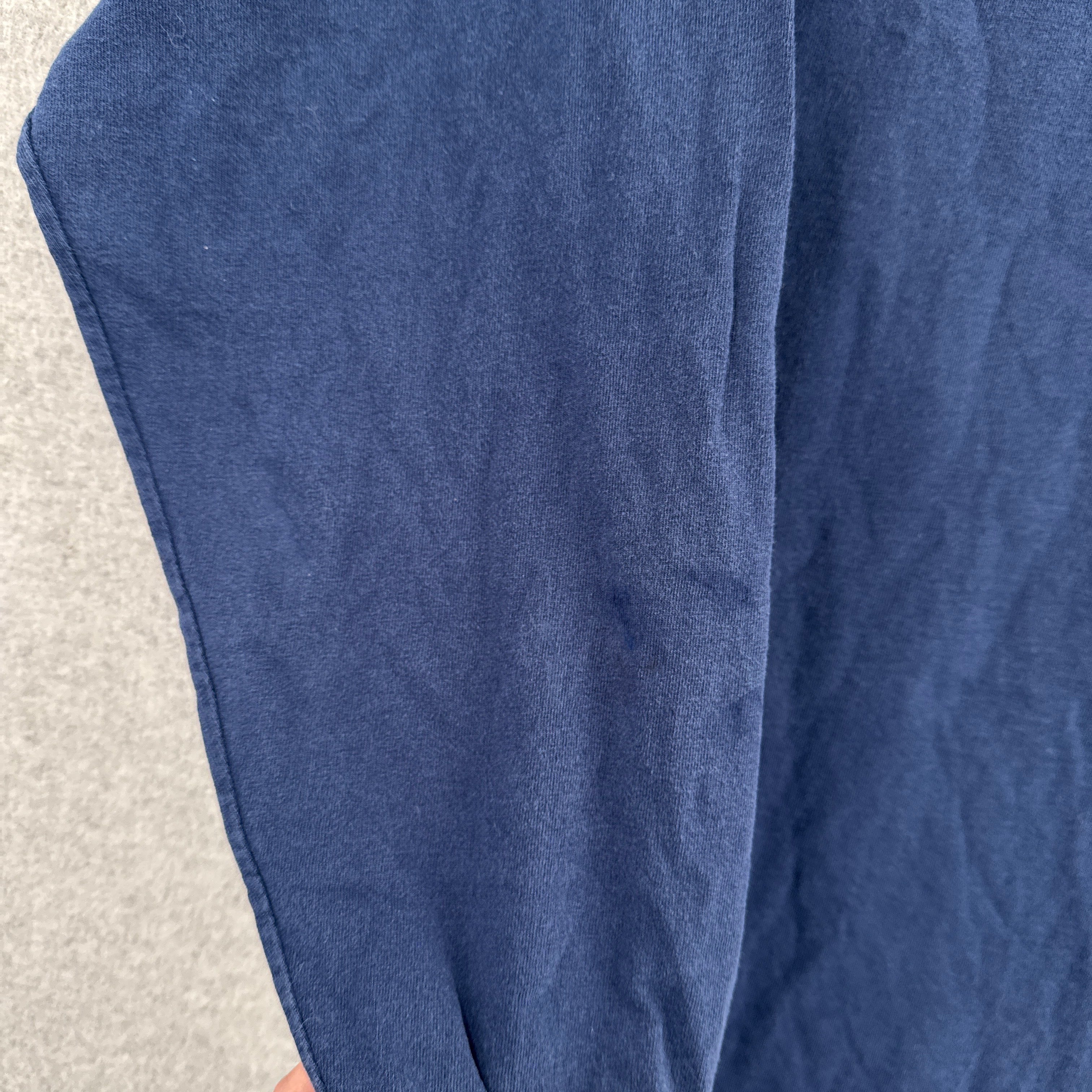 Close-up of blue fabric on a textured surface. dark discolouration on sleeve