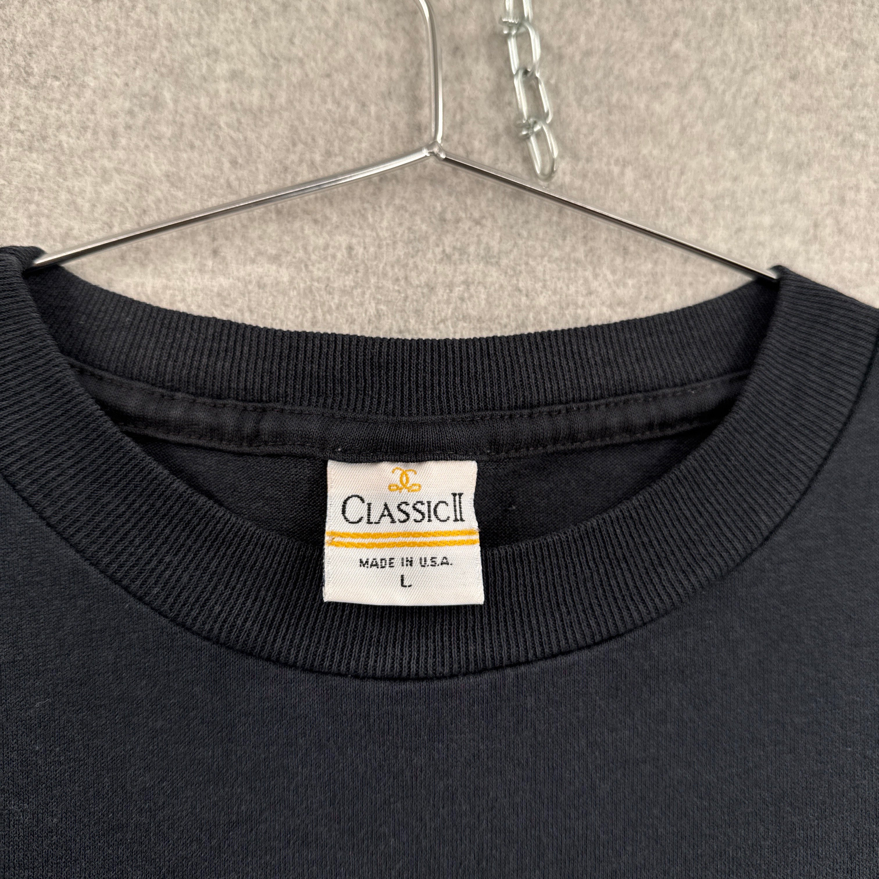 Black sweatshirt with a brand label on a beige surface. Made in USA size Large