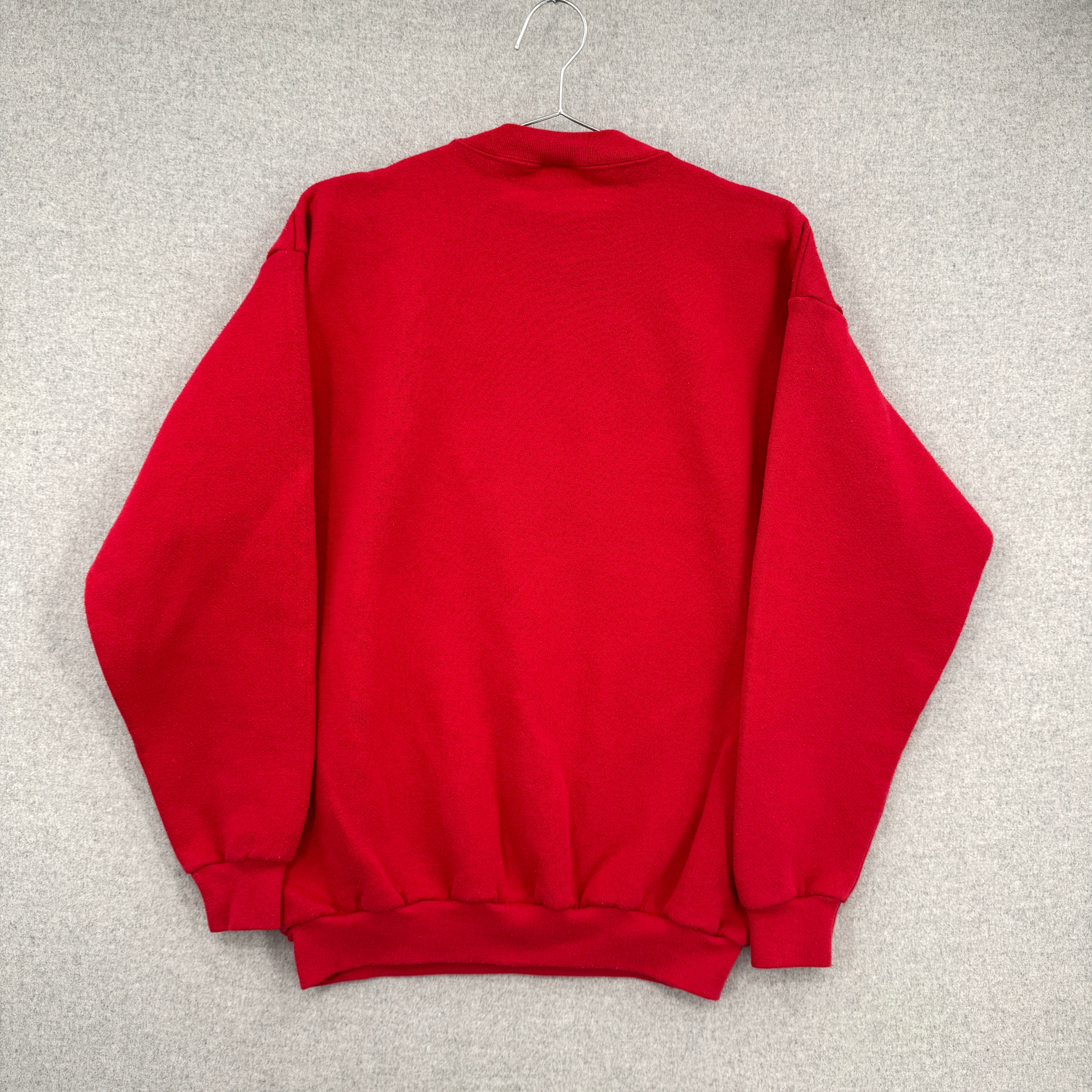 Red sweatshirt on a hanger against a gray background. Back of sweatshirt, blank