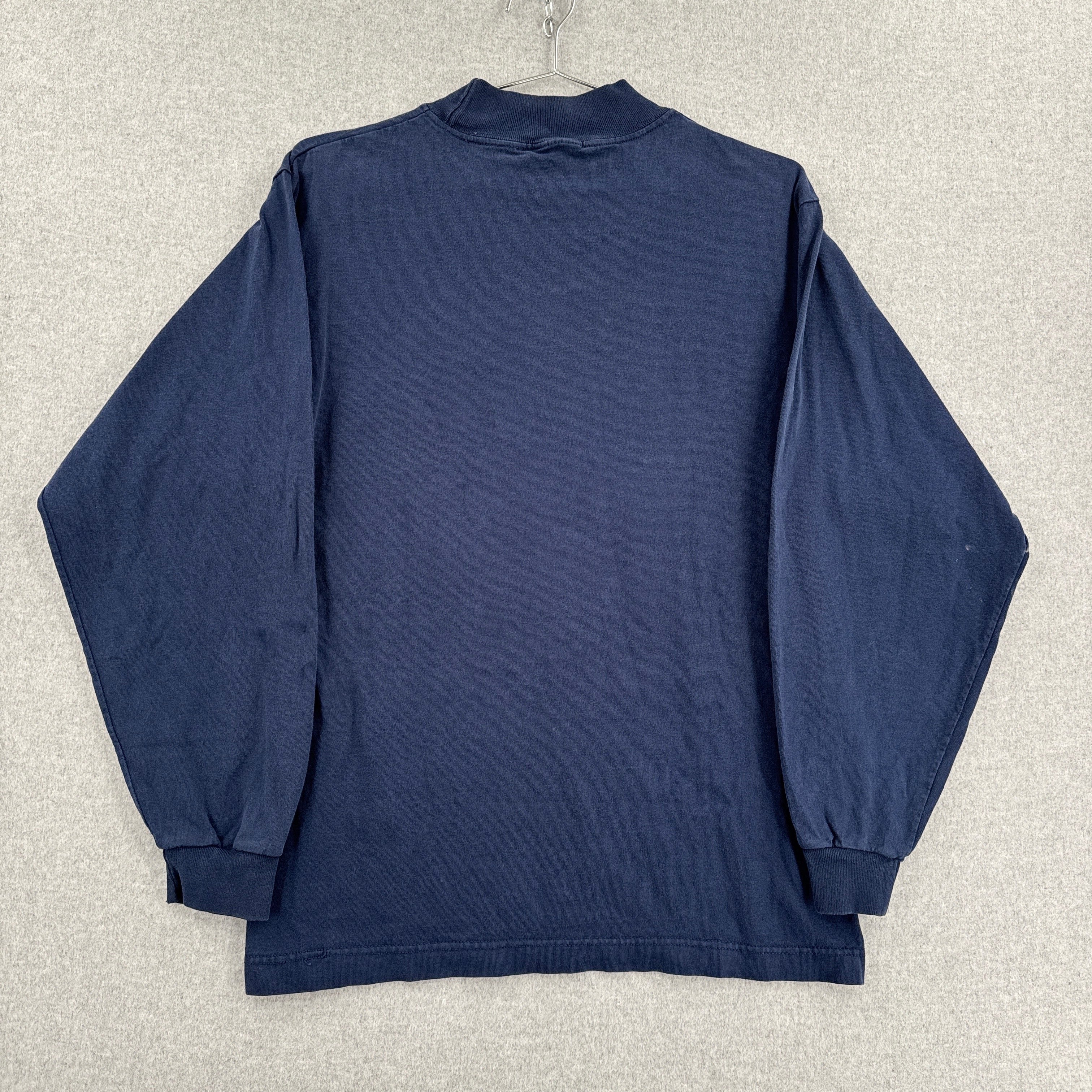 Navy blue long-sleeve shirt on a hanger against a neutral background back