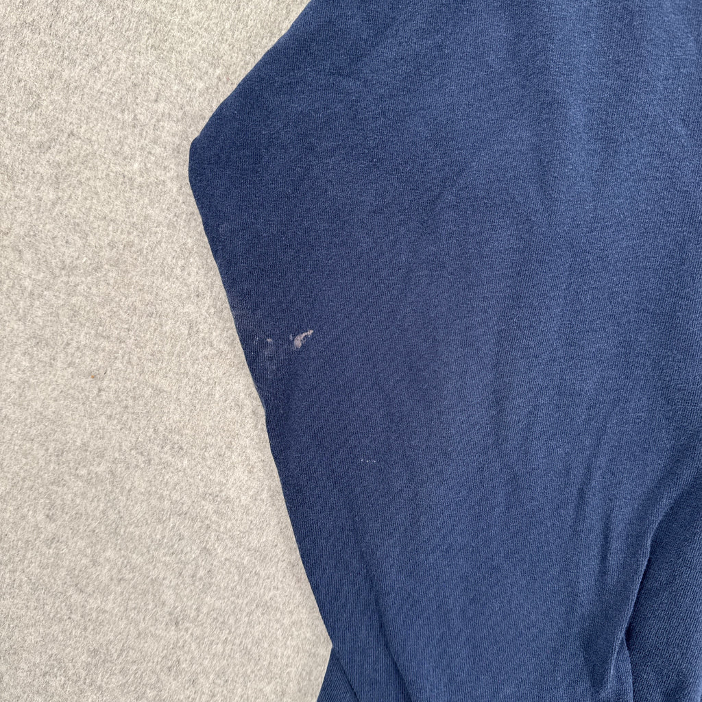 Blue fabric on a textured beige surface. stain spots on sleeve