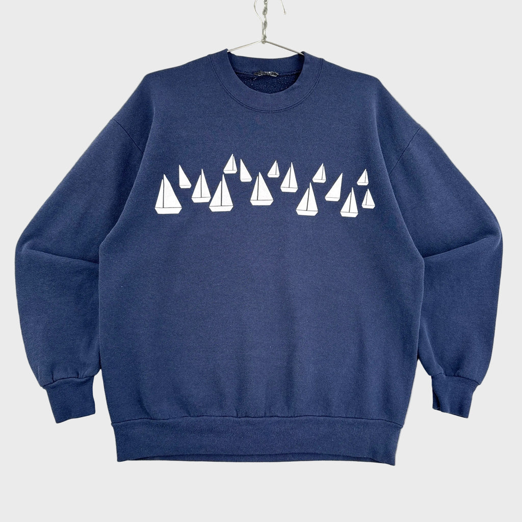Navy blue sweatshirt with white sailboat pattern on a neutral background