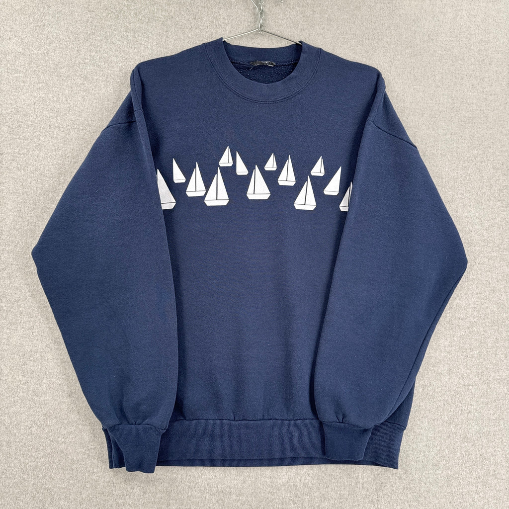 Navy blue sweatshirt with white sailboat pattern on a beige background