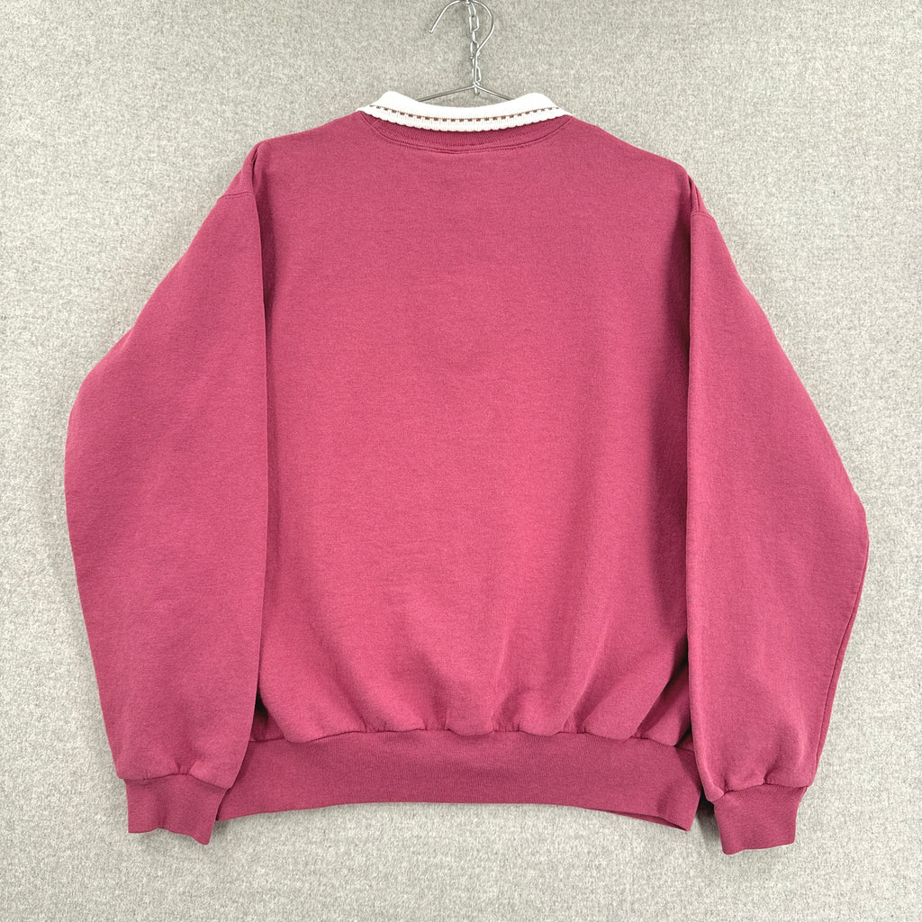 Pink sweatshirt on a hanger against a gray textured wall