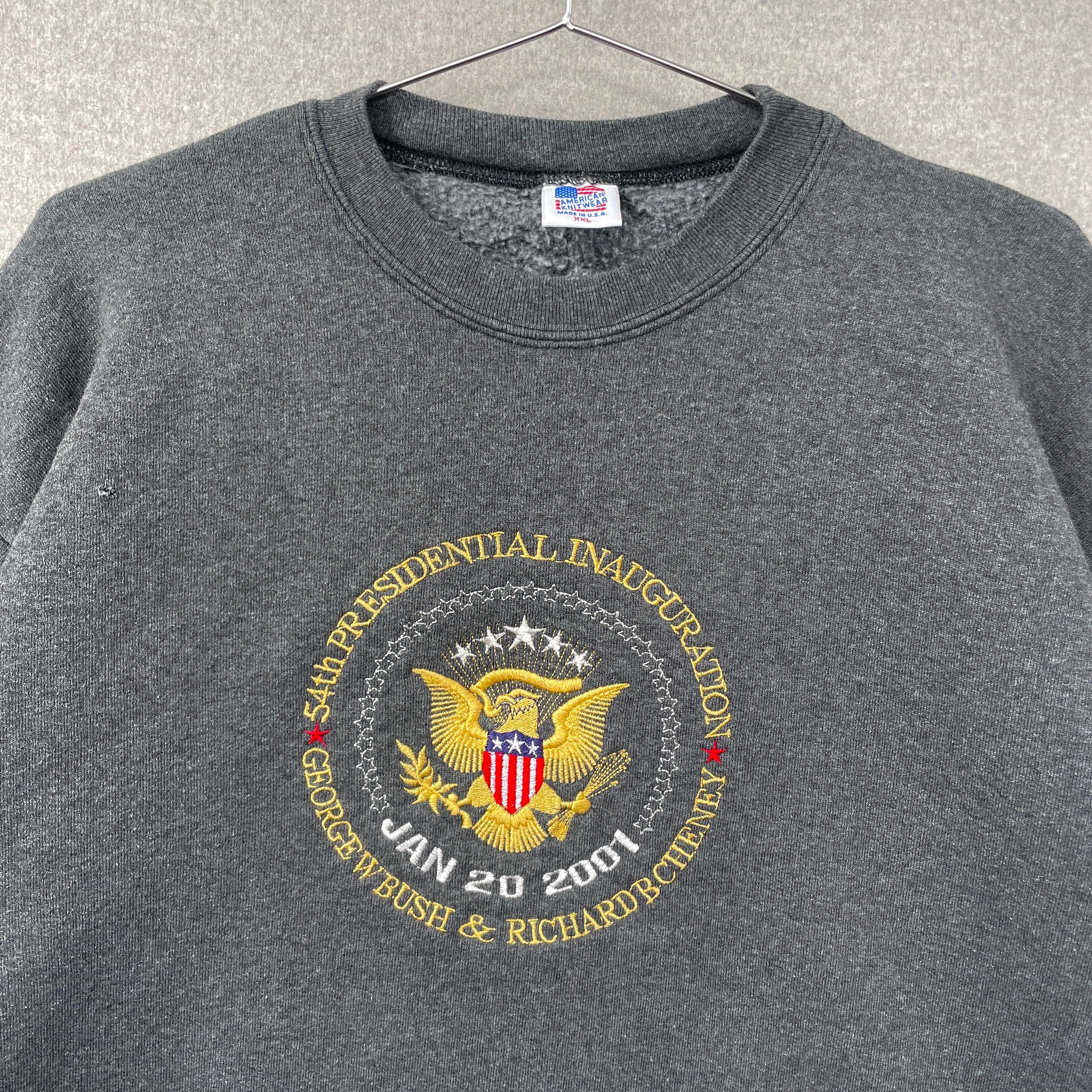 Gray sweatshirt with presidential inauguration emblem on a hanger