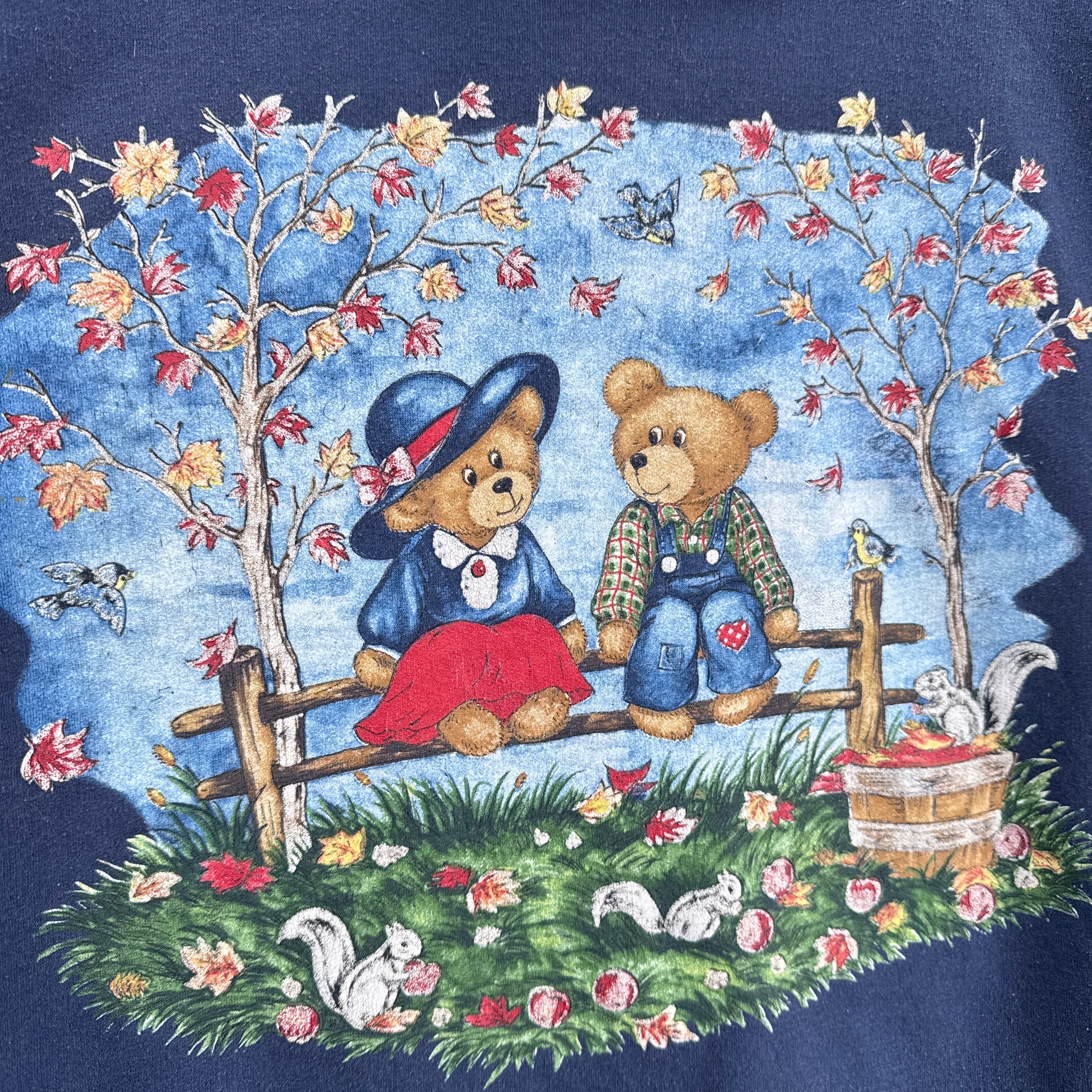 Decorative fabric with teddy bears, fall leaves tree, and floral elements on a blue background with squirrels