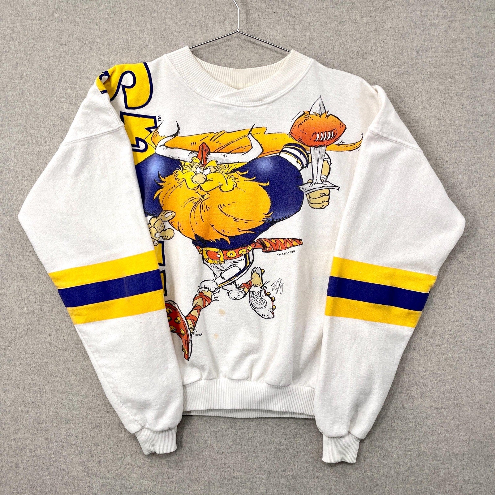 White sweatshirt with a cartoon character design on a gray background