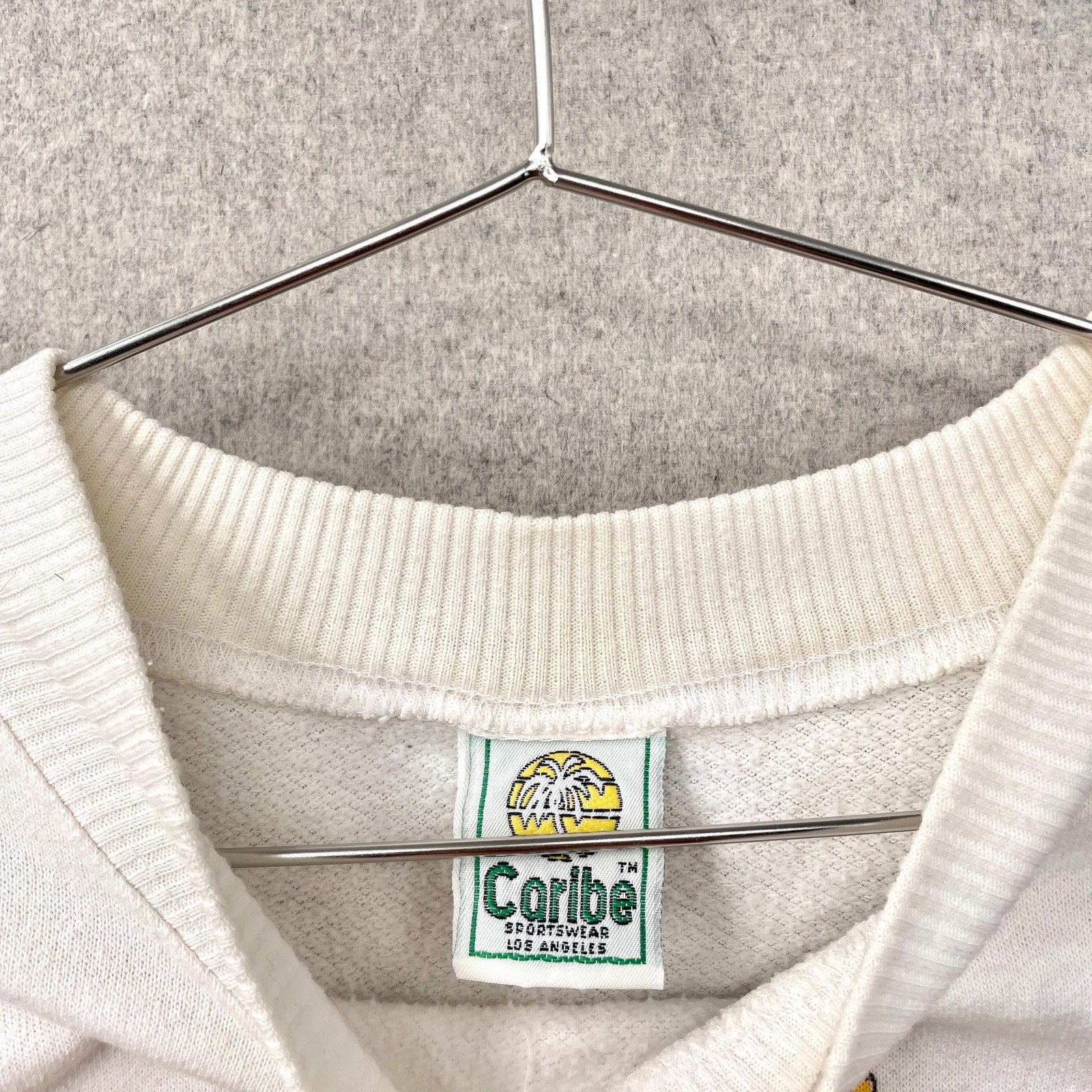 White sweater with a visible brand label on a hanger