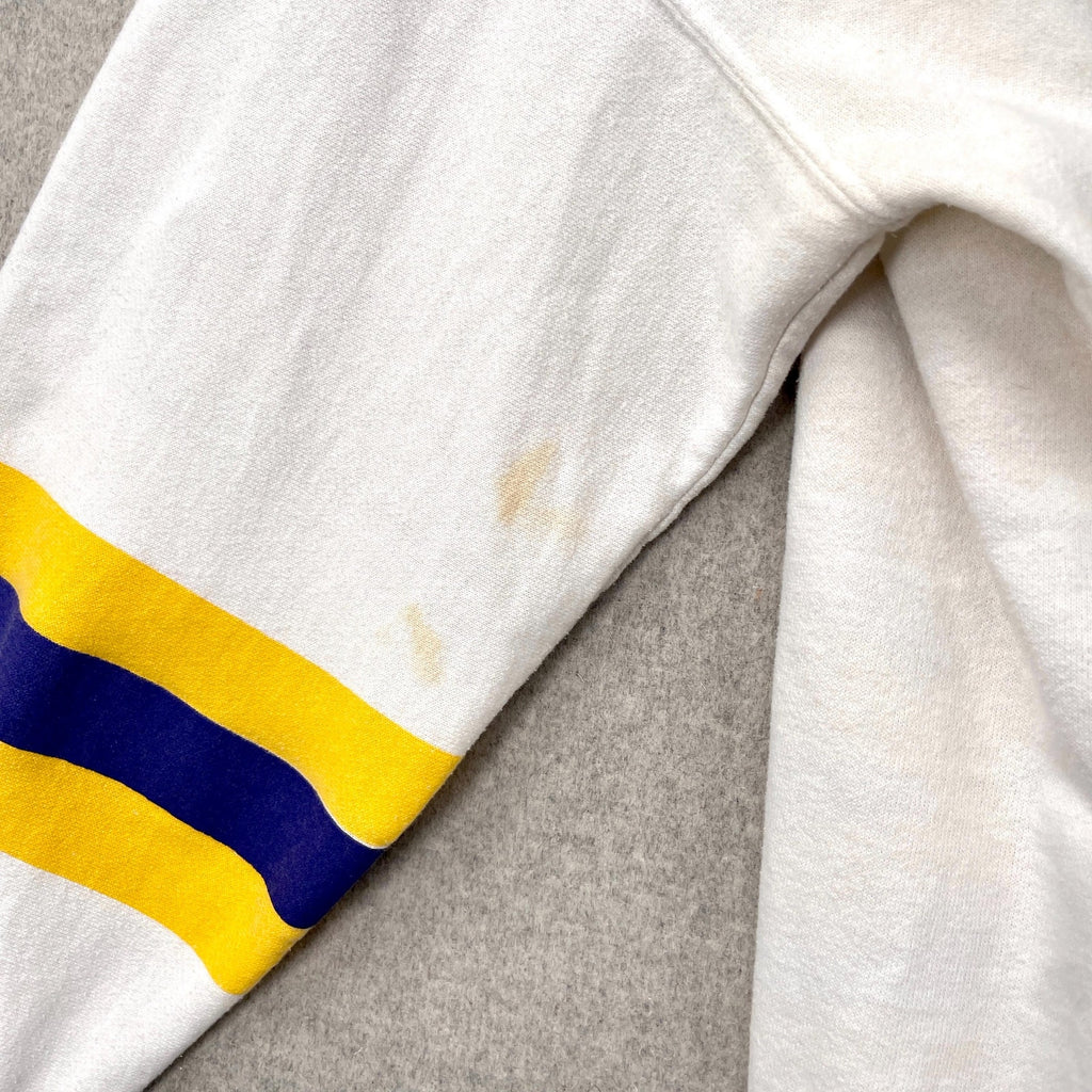 Close-up of a white fabric with yellow and blue stripes on a gray background. stain spots