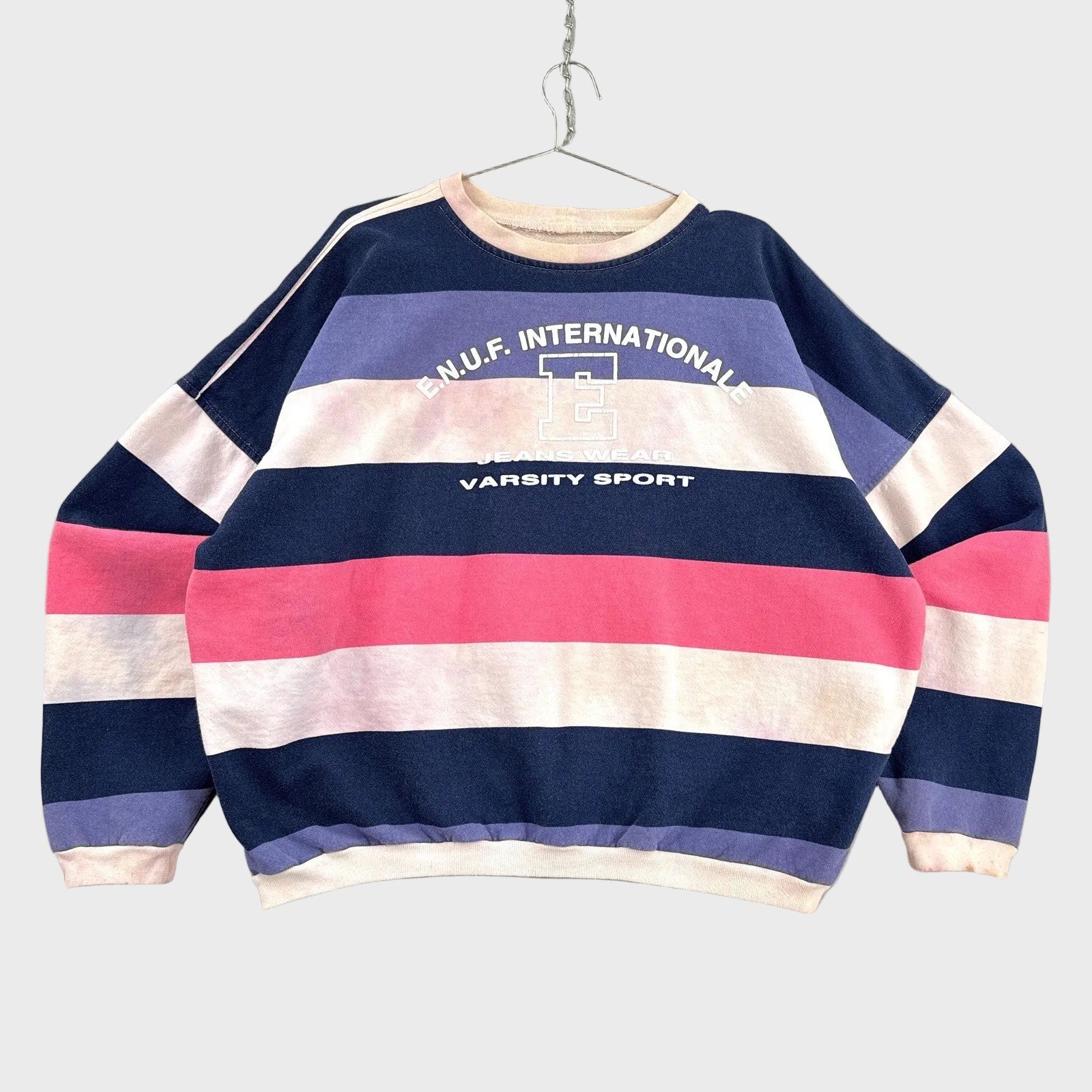 Striped sweater with text on a gray background. Enuf international varsity sport.