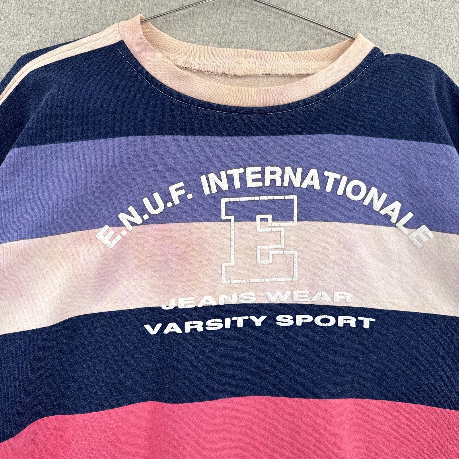 Colorful striped sweater with text and logo on a hanger