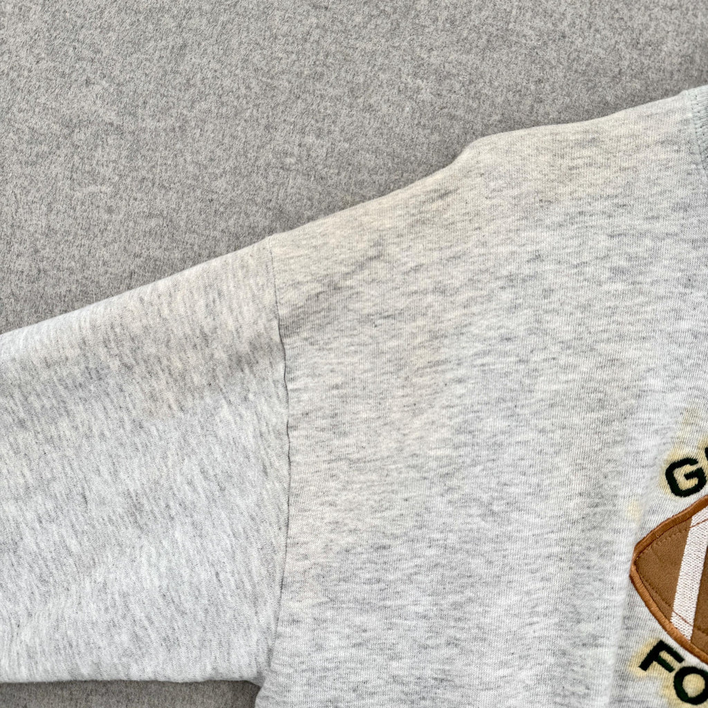 Gray sweatshirt with a logo on a gray background. yellowing/discolouration