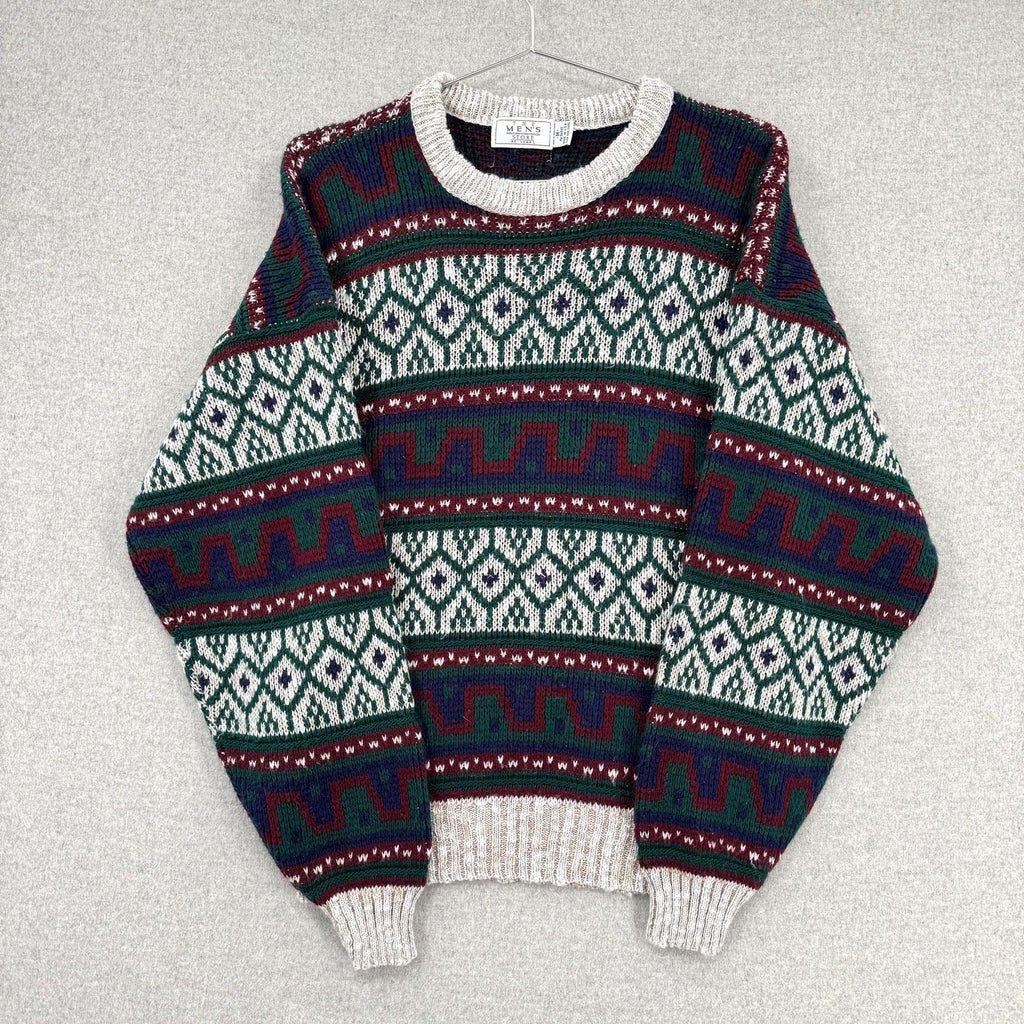 Patterned sweater on a hanger against a gray background