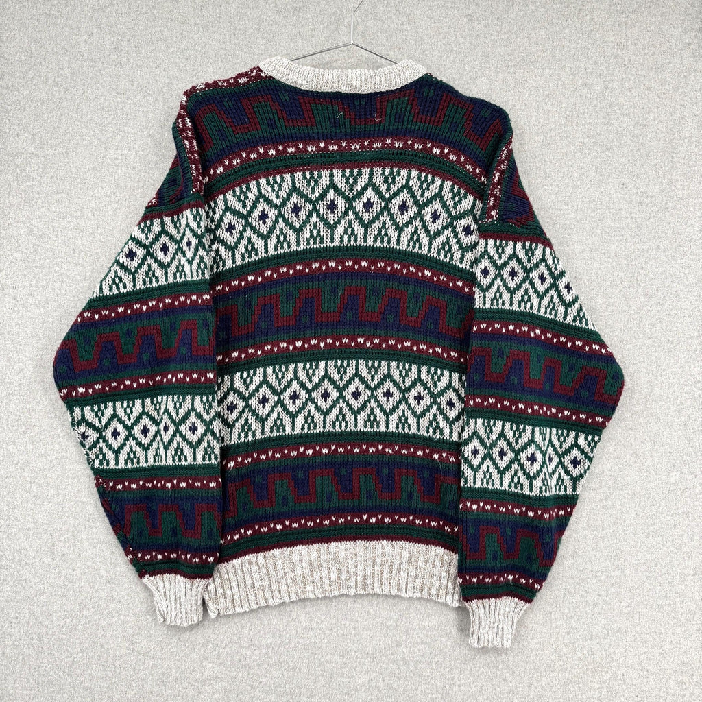 Patterned sweater on a hanger against a light gray background