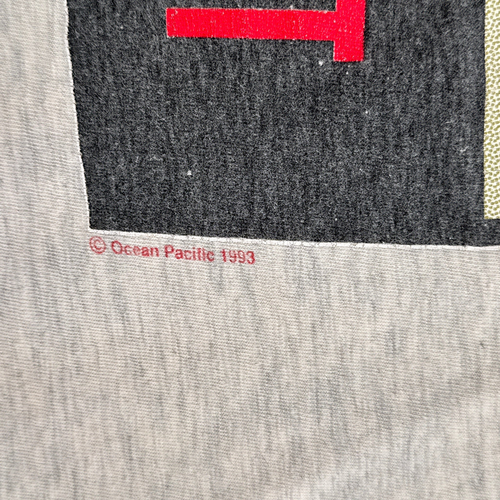 Close-up of a gray fabric with a red and black logo and text. 1993 date stamp