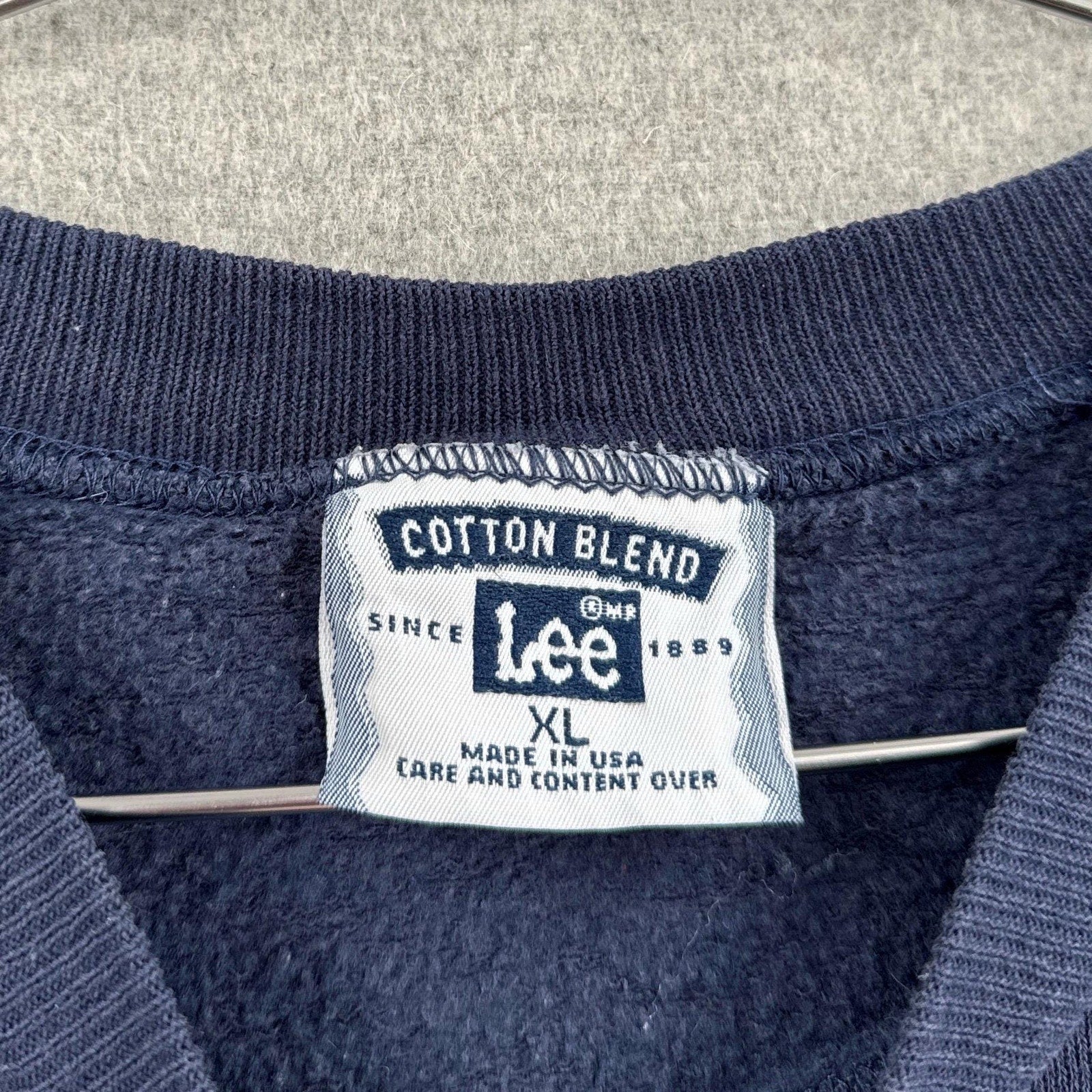 Lee brand label on a navy blue garment with 'Cotton Blend' text. XL made in USA