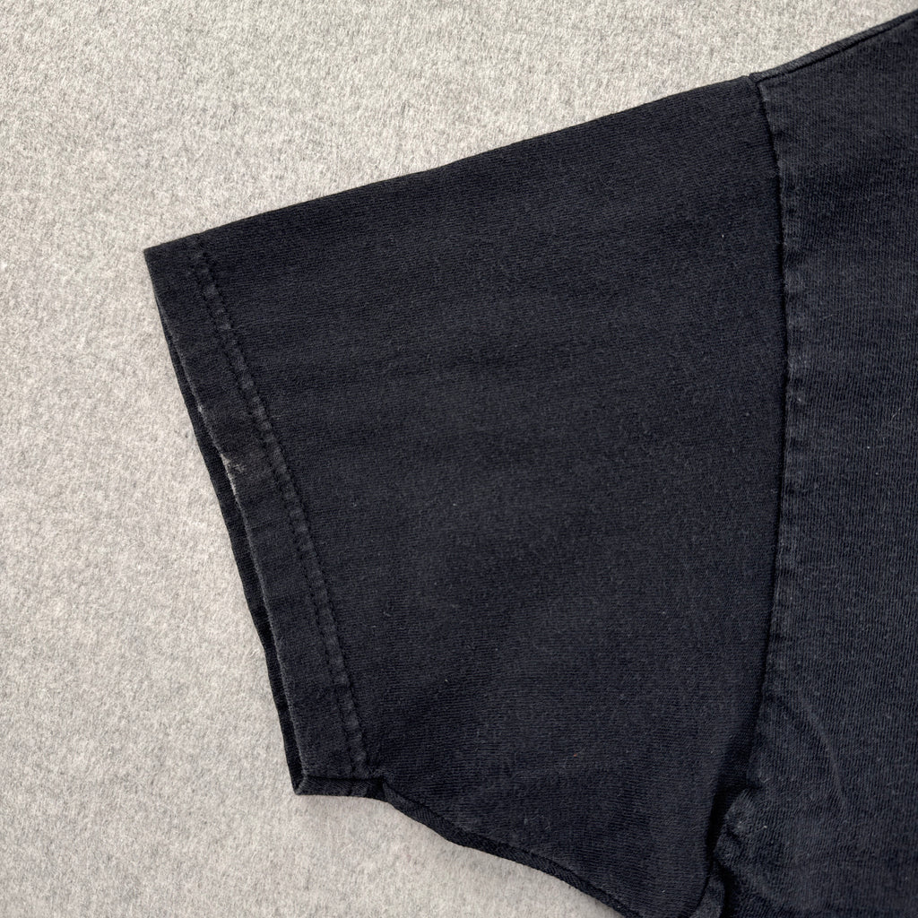 Close-up of black shorts on a light gray surface. stain spot on sleeve