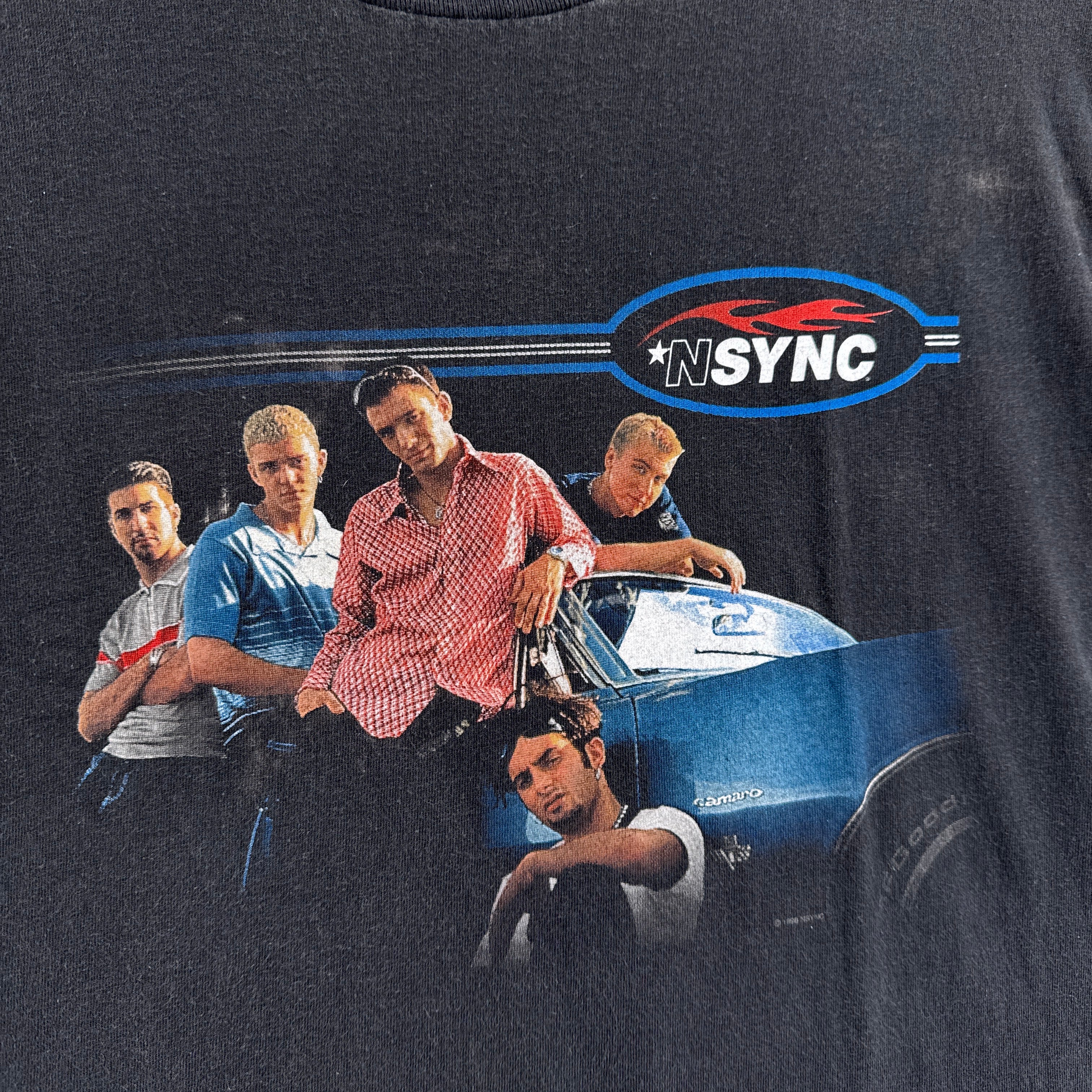 Black t-shirt with a graphic of a group of people and the NSYNC logo.