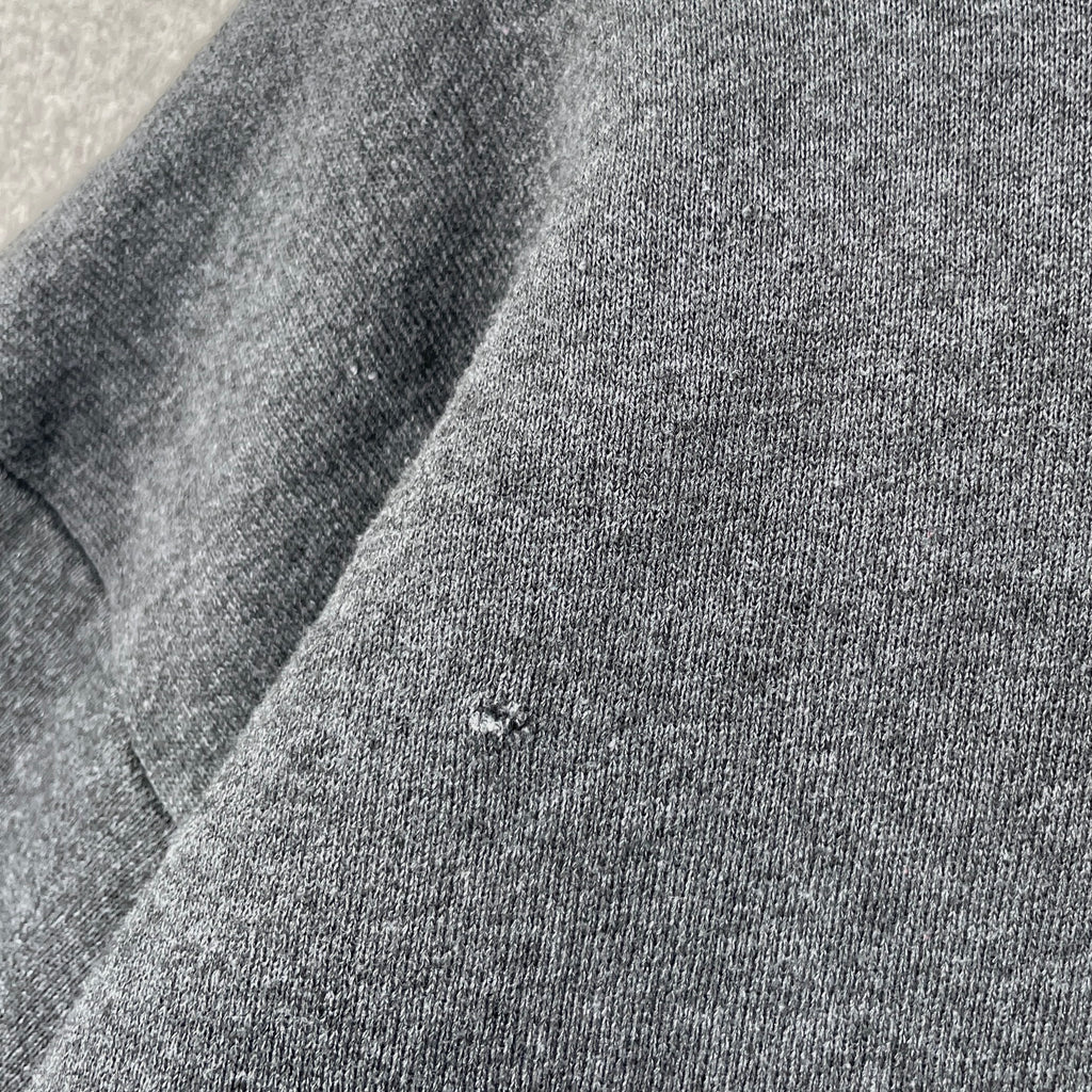 Close-up of gray fabric with a small hole