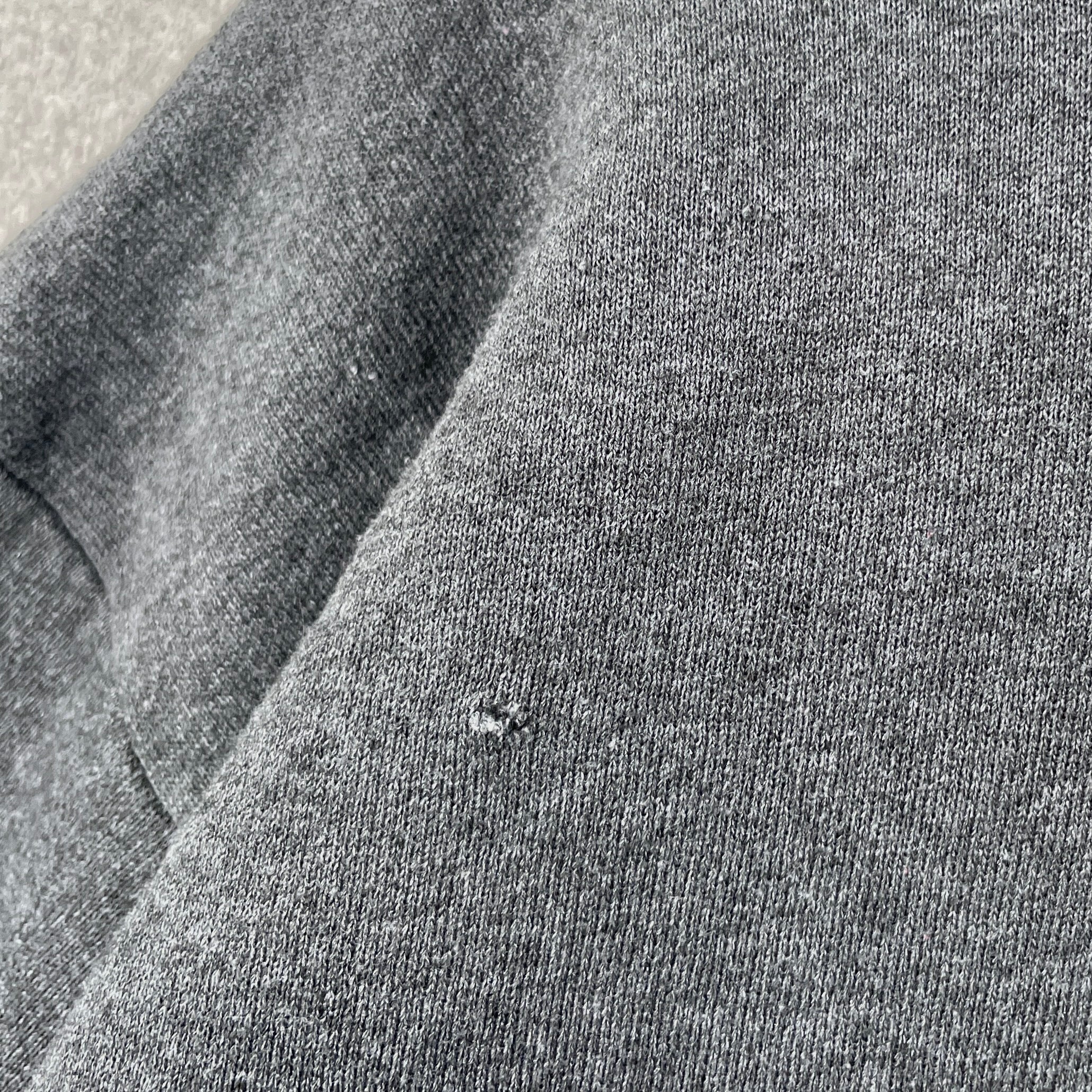 Close-up of gray fabric with a small hole