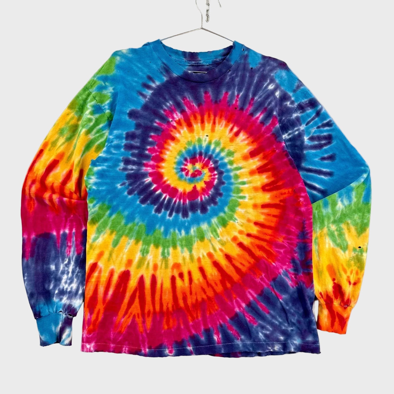 Colorful tie-dye long-sleeve shirt with a spiral pattern on a gray background