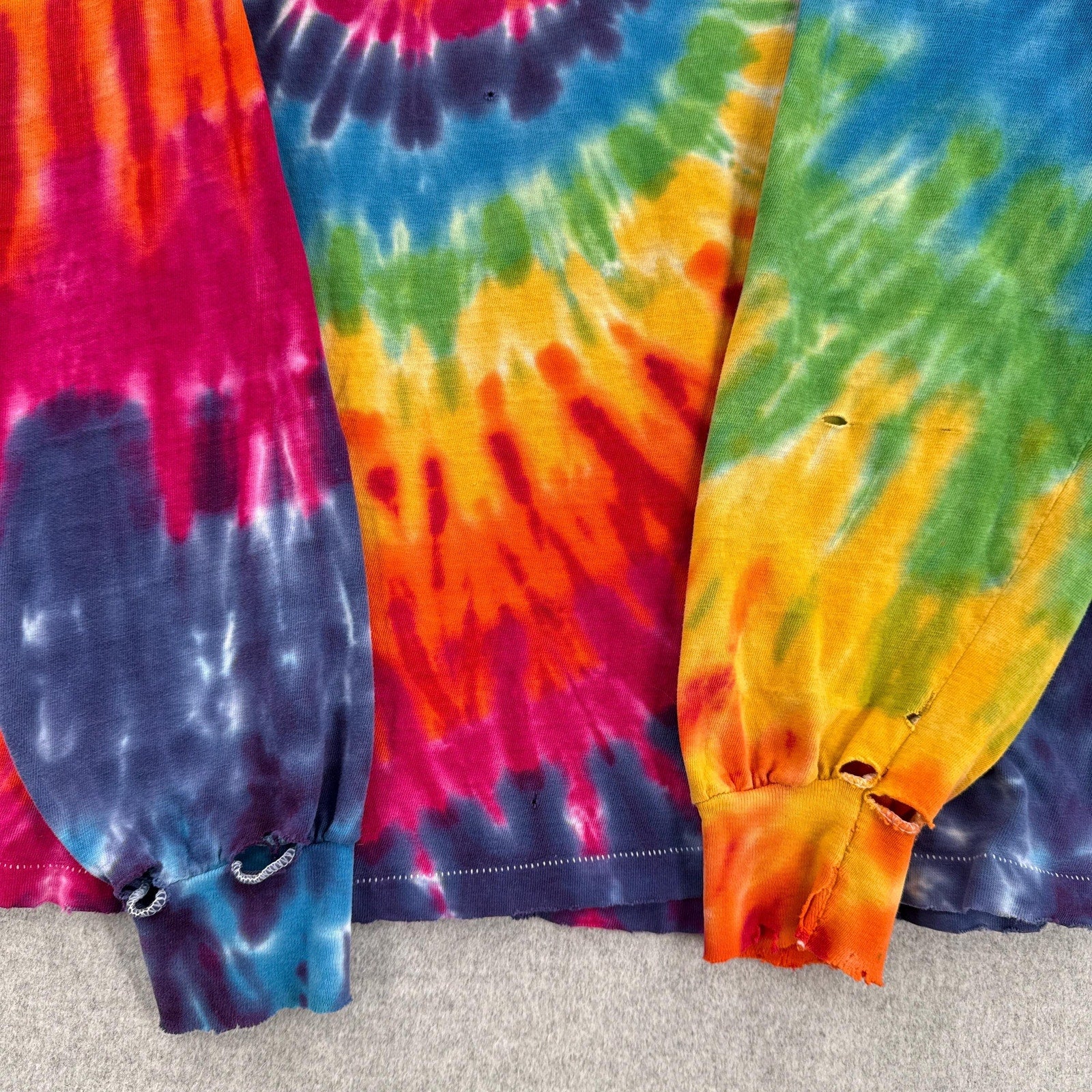 Three colorful tie-dye skirts displayed on a carpeted floor.