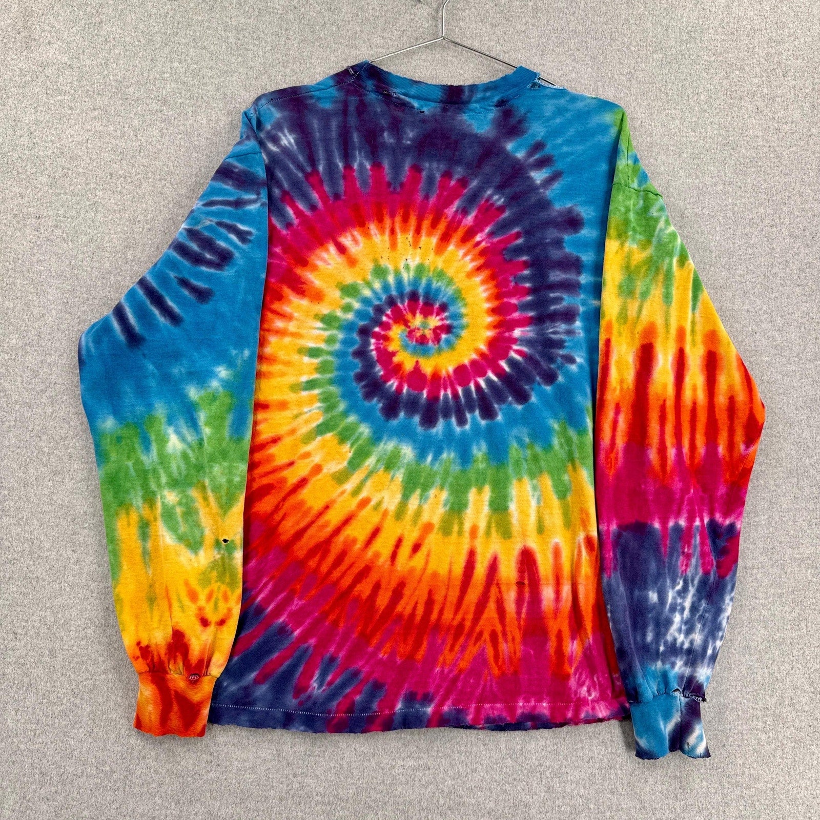 Colorful tie-dye long-sleeve shirt with a spiral pattern on a gray background