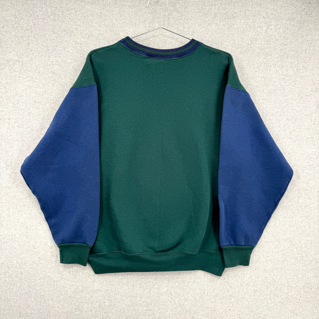 Green and blue sweatshirt on a hanger against a light gray background