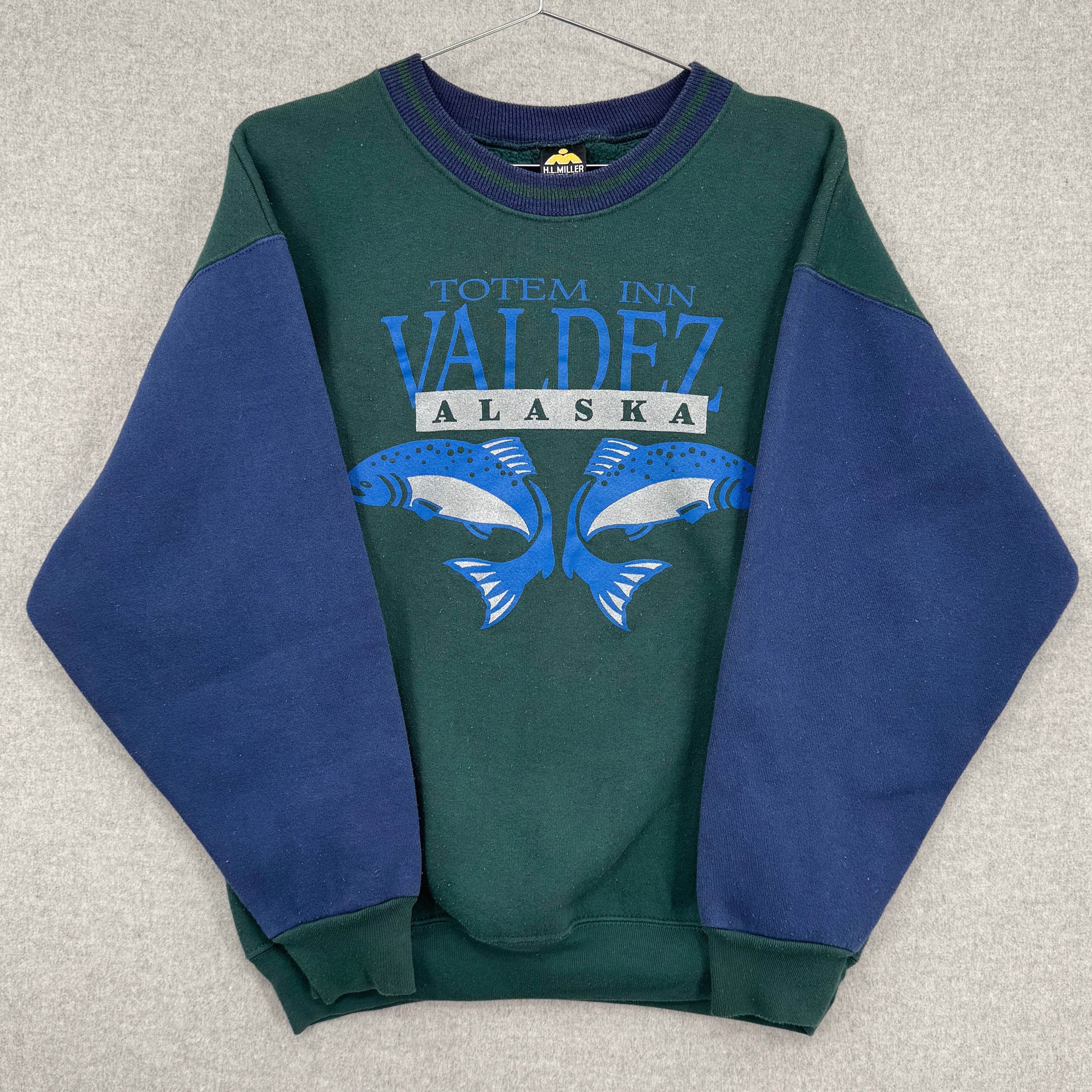 Green and blue sweatshirt with 'Valdez, Alaska' text on a gray background