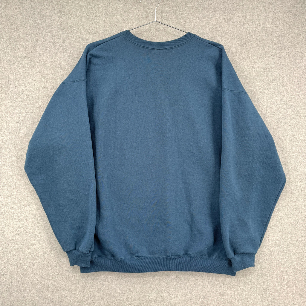 back of blue sweatshirt on a hanger against a beige wall