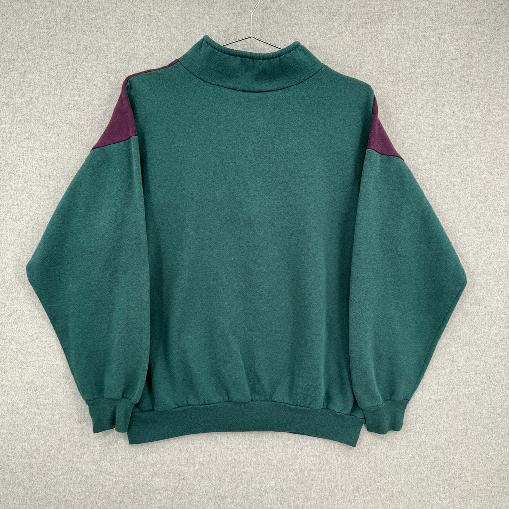 Green sweater with purple accents on a blank background.