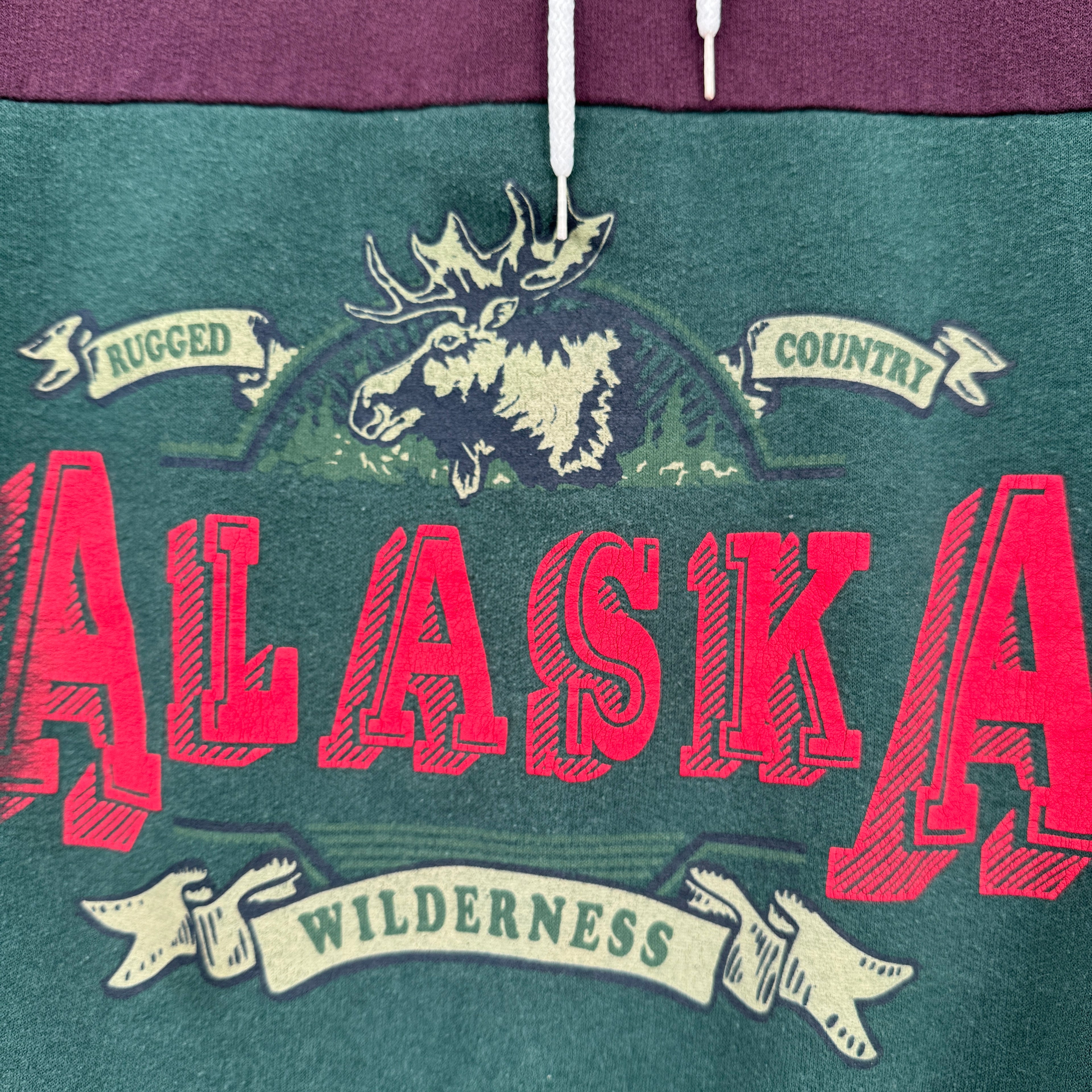 Sweatshirt with 'Alaska' graphic and moose design on a green background