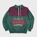 Green and purple sweatshirt with 'Alaska' graphic on a white surface