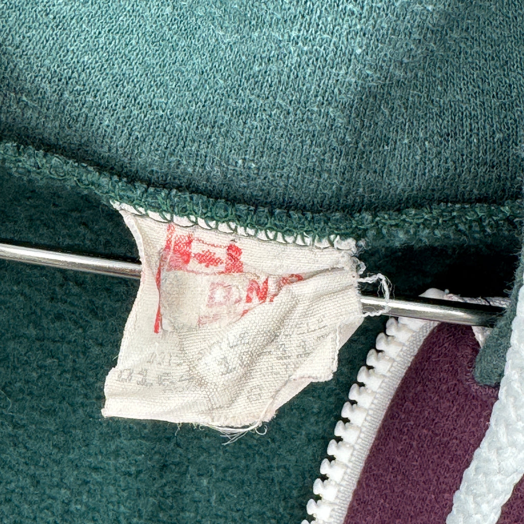 Close-up of a label on a green garment. Size Large. Made in Canada.