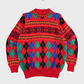 A red knit sweater with a colorful argyle and geometric pattern, hanging on a clear hanger against a light gray textured background.