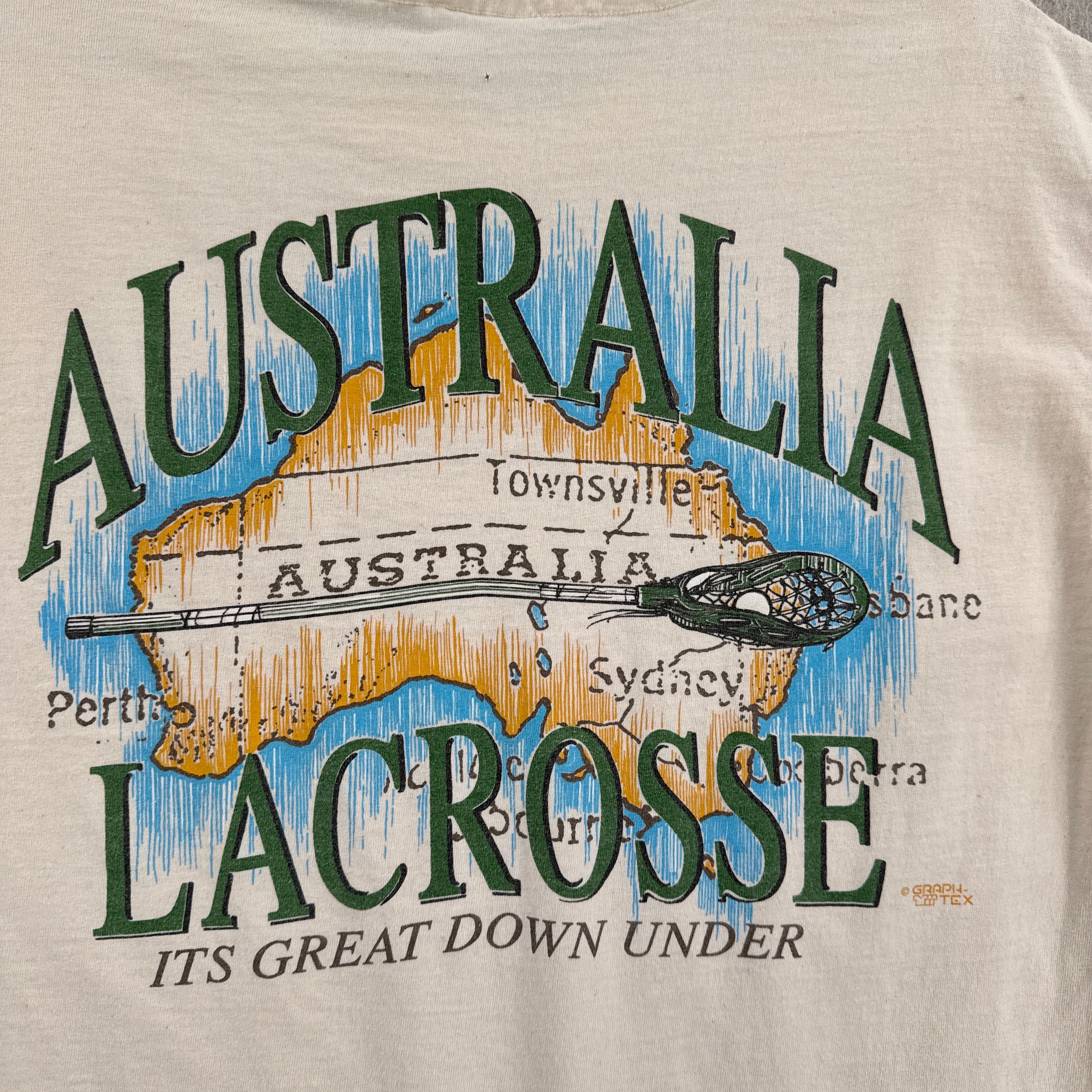 T-shirt with a lacrosse design featuring Australia and text on a beige background