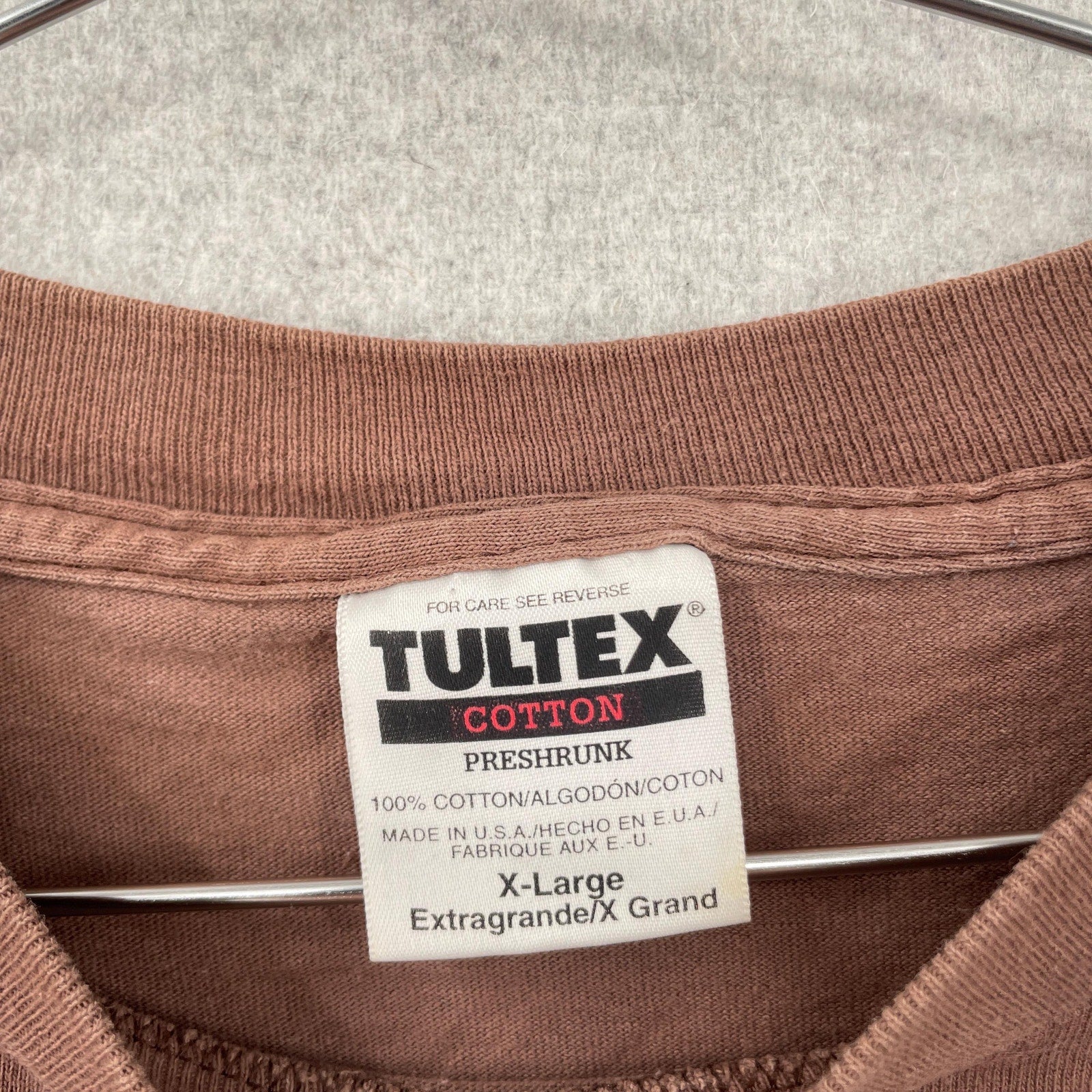 Brown fabric with Tultex cotton label on a gray background