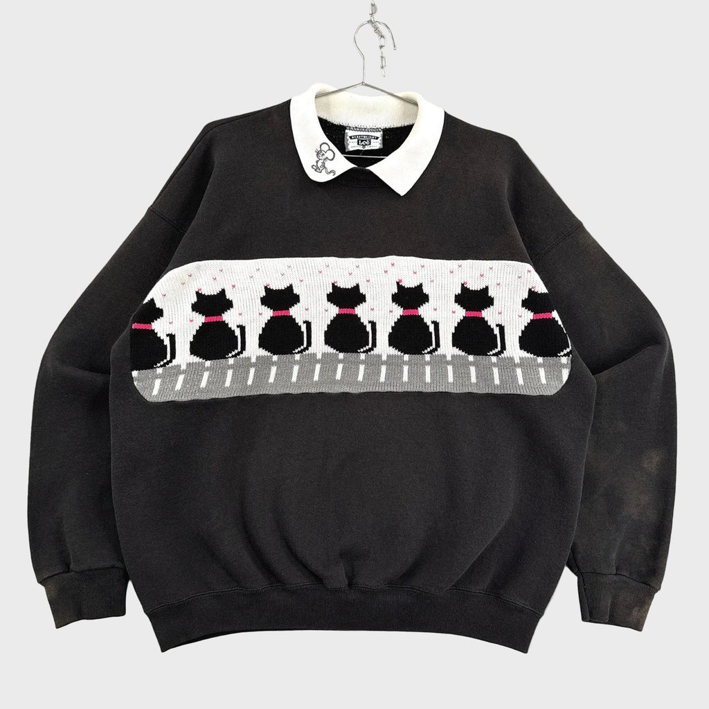 Black sweater with cat pattern on a gray background