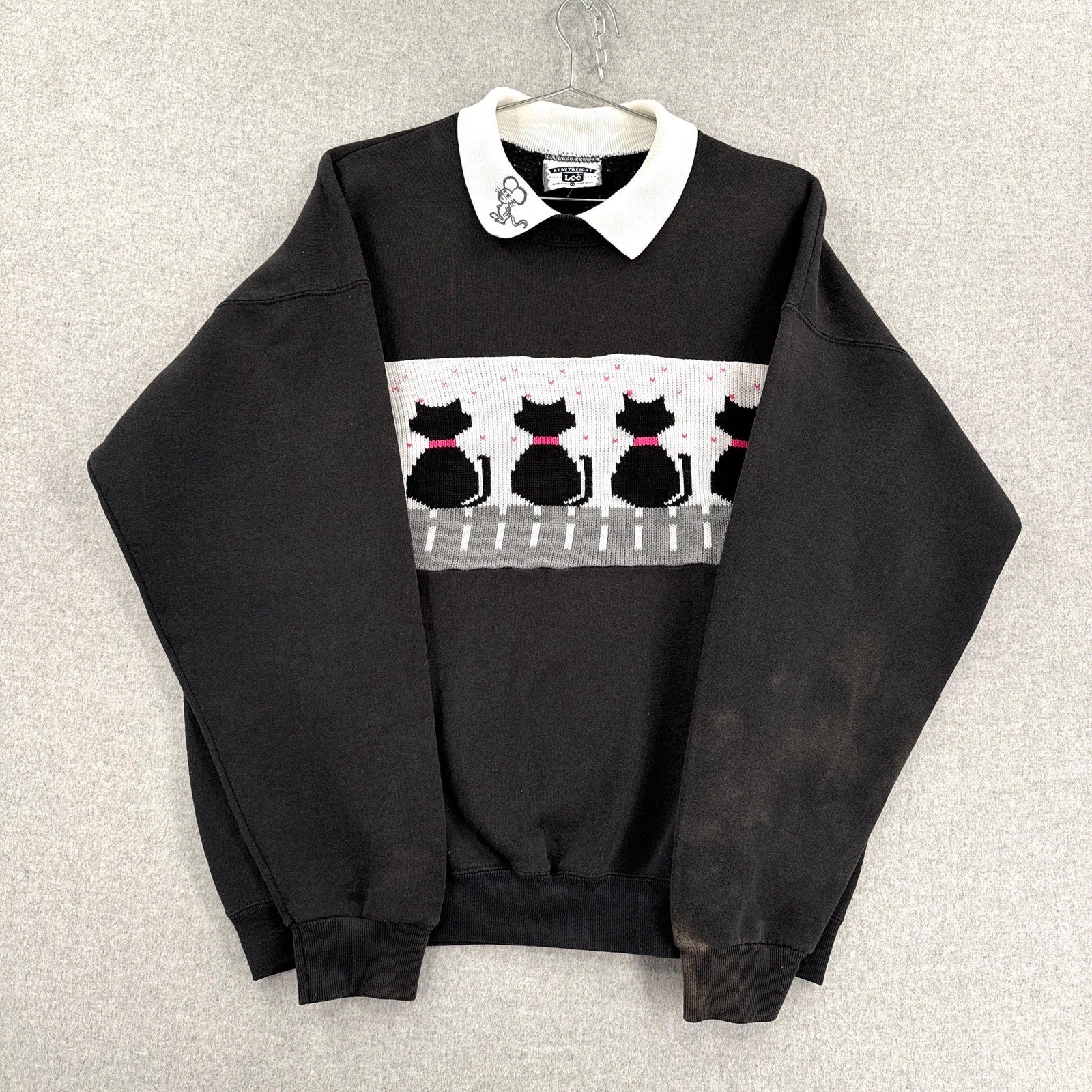 Black sweater with cat pattern on a gray background